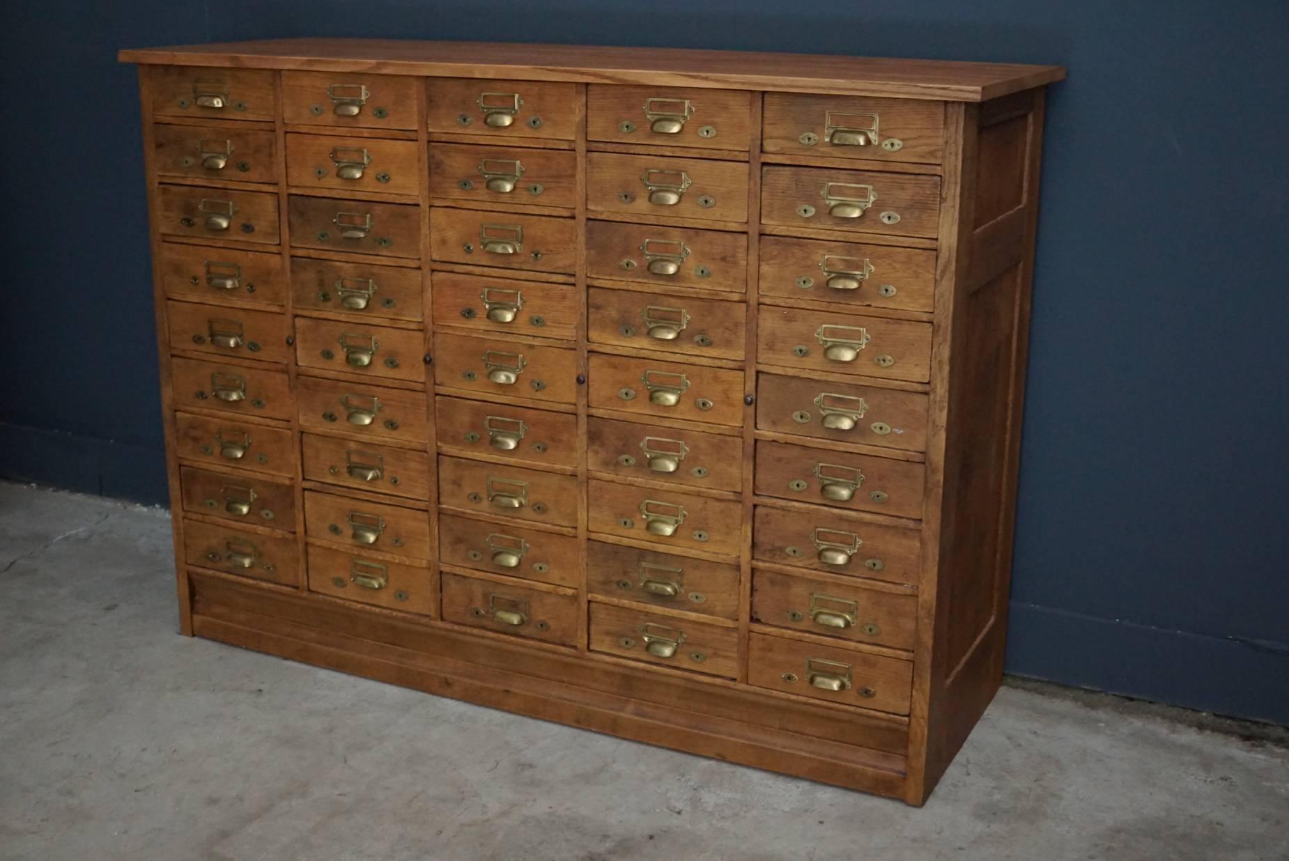 This oak apothecary cabinet was designed and made, circa 1900 in the Netherlands. It features 45 drawers with brass hardware and remains in a very good vintage restored condition.