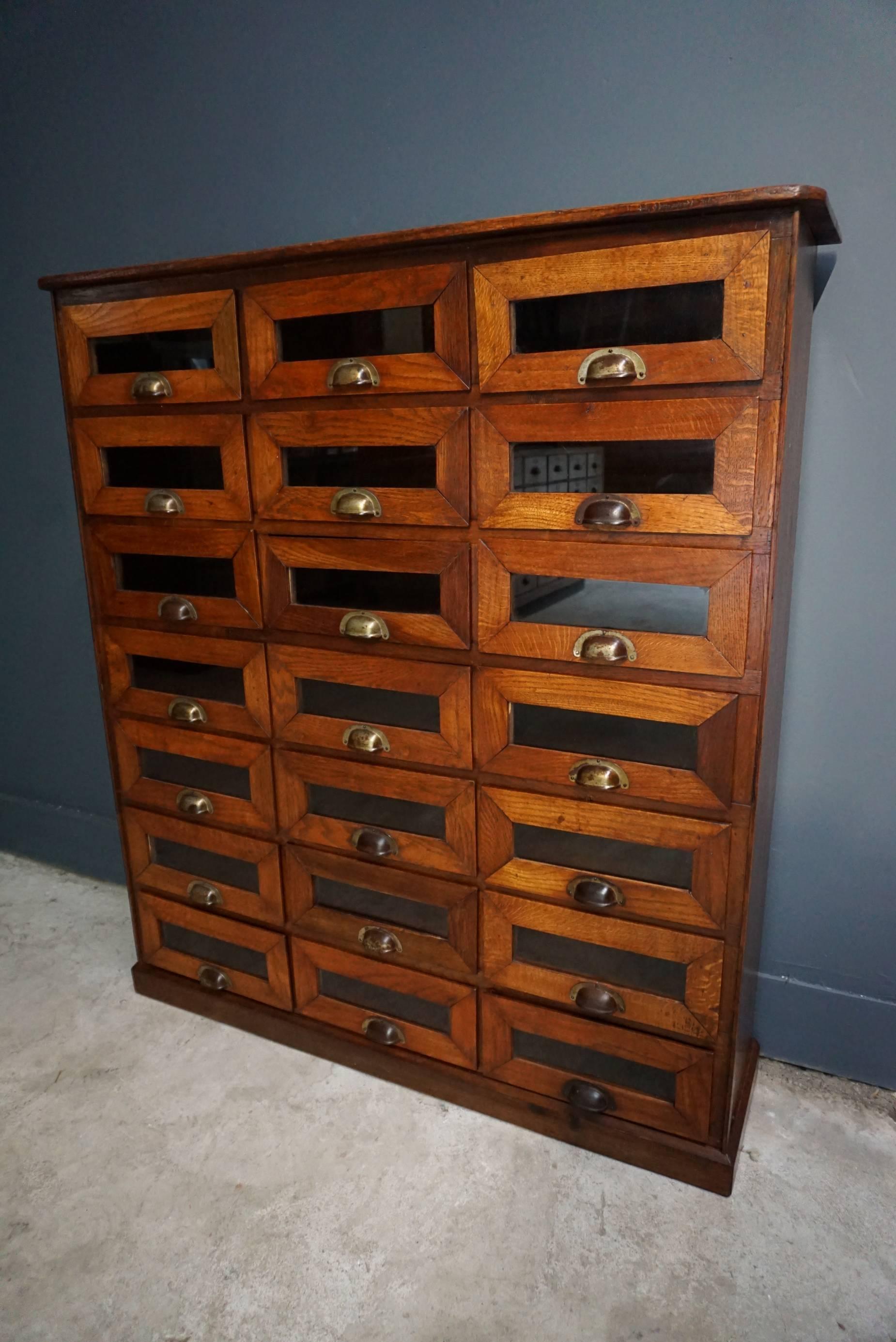 This vintage haberdashery shop cabinet originates from the United Kingdom. It is made from oak and features 21 drawers. It is restored and the drawers open and shut smoothly. The inside of the drawers measure 22 x 28.7 x 10.7 cm 