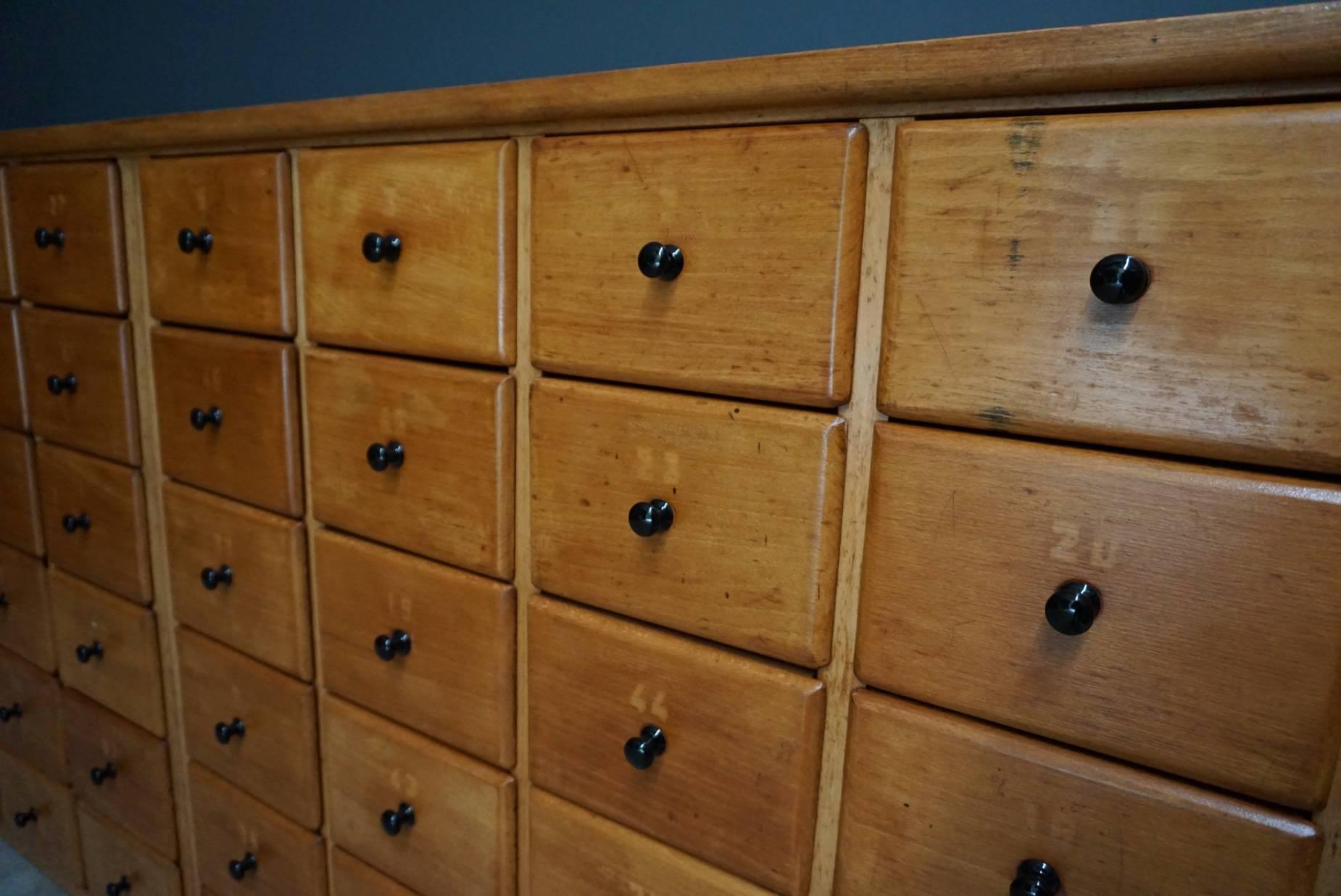 This apothecary cabinet was designed and made circa 1950 in the Netherlands. It features 48 drawers with metal knobs and remains in a very good vintage restored condition. The inside of the drawers measure: 34 x 18 x 13 cm
