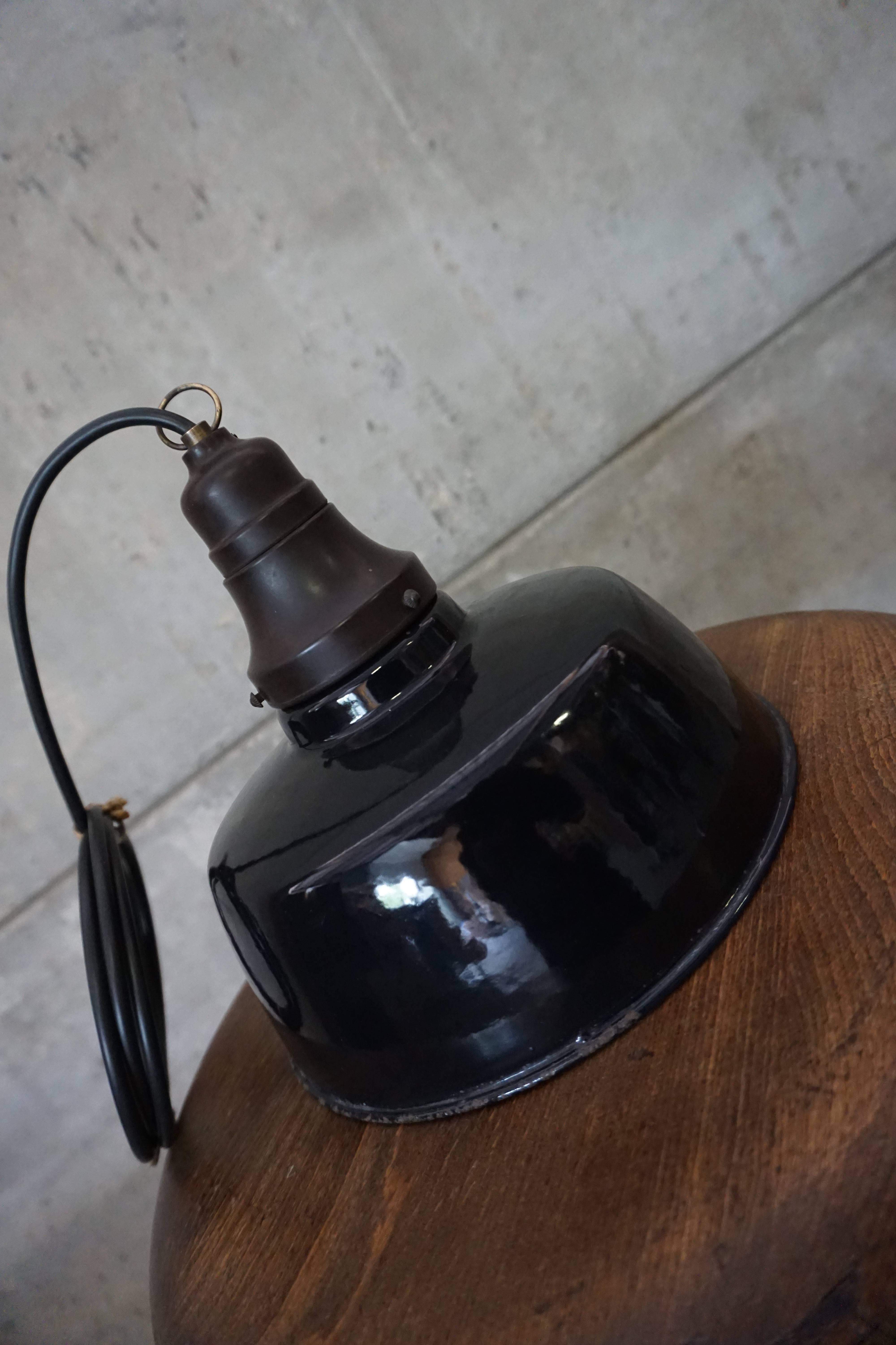 This factory lamp was manufactured in Belgium in the 1930s. This version features a bakelite top and fitting. The lamp comes with a +-2m wire and a E27 fitting for regular light bulbs.