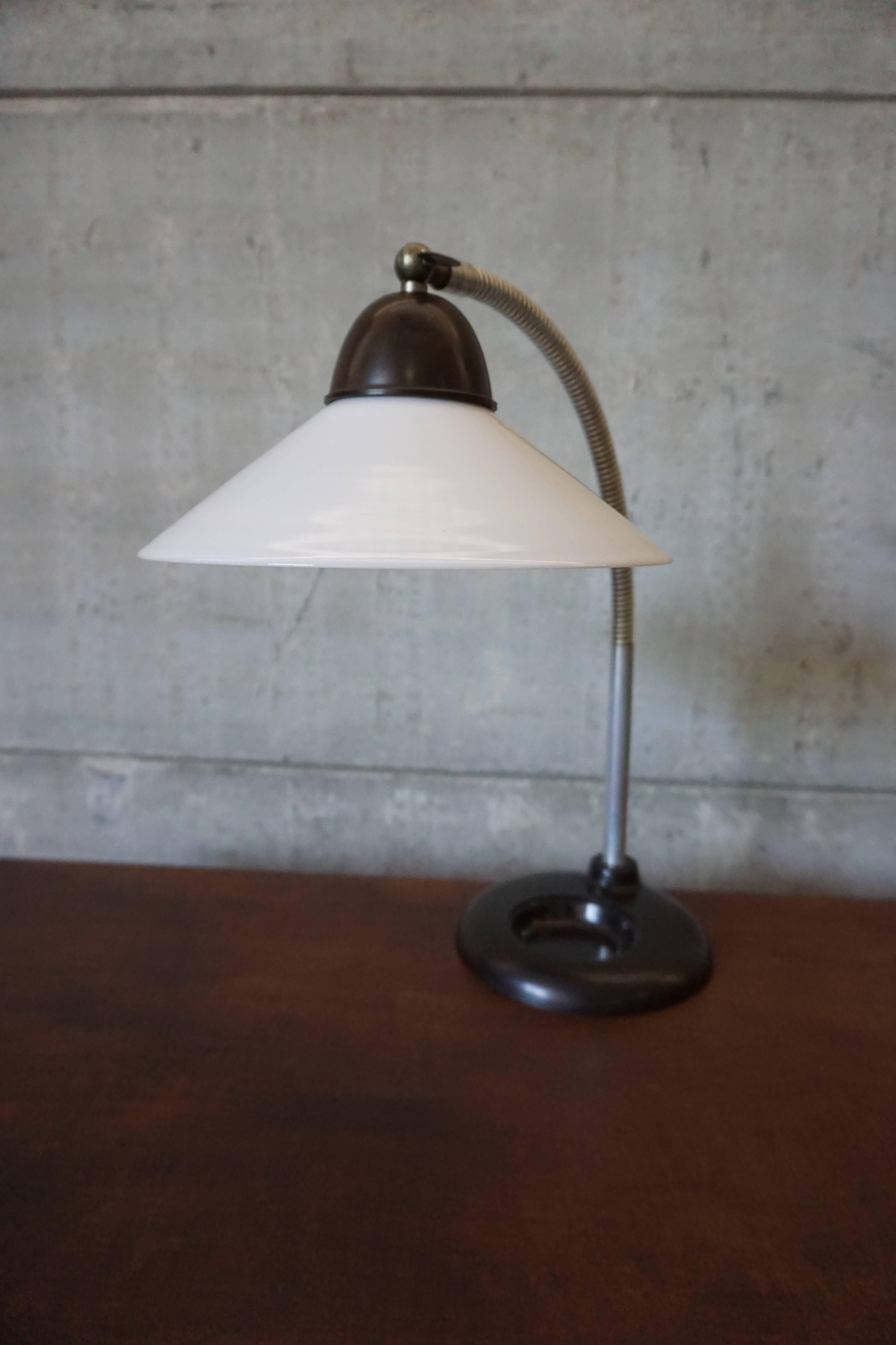 This vintage opaline desk lamp was designed in the 1930s, and manufactured in Germany. The lamp features an opaline glass shade with a bakelite base and fitting, marked with the DGRM stamp and has recently been rewired. In a good vintage condition,