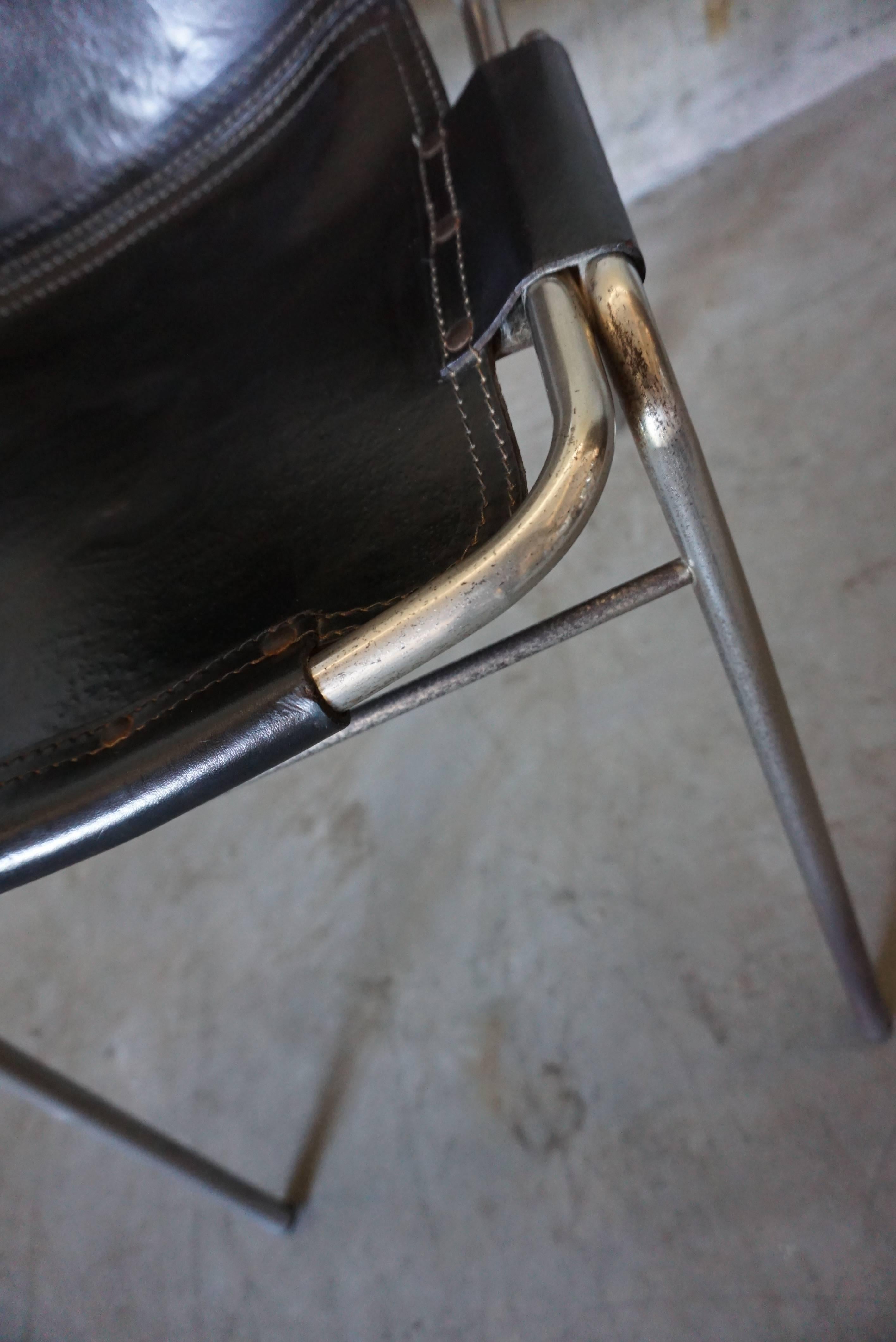 This chair was designed by Charlotte Perriand for Les Arcs during the 1960s. It features a chrome tubular frame with thick black leather seats.