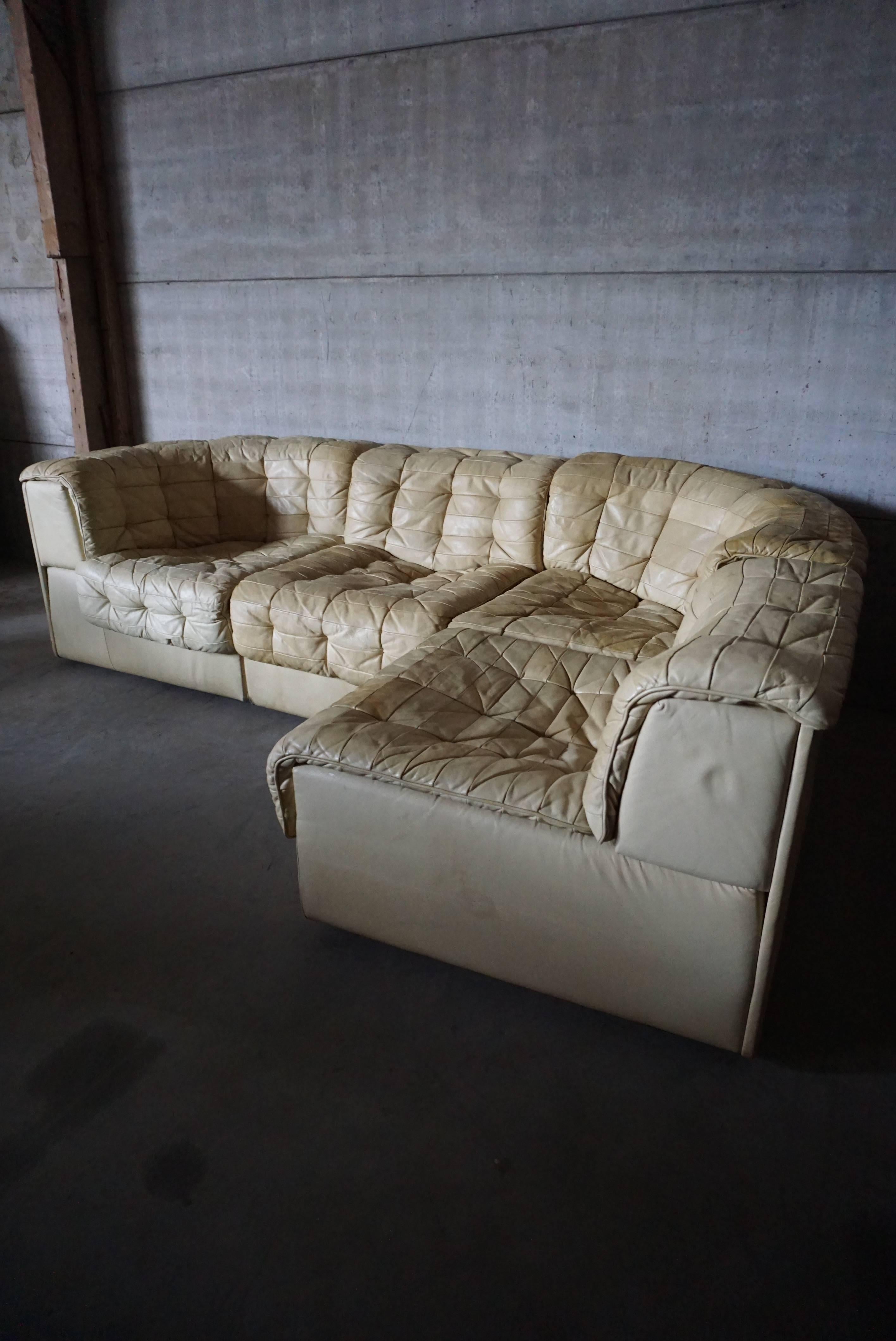 Very comfortable DS11 model sofa manufactured by de Sede in the 1970s. It features four elements and is upholstered with patchwork leather. It remains in a fair vintage condition with signs of use, some stains and small tears. Could recolored or
