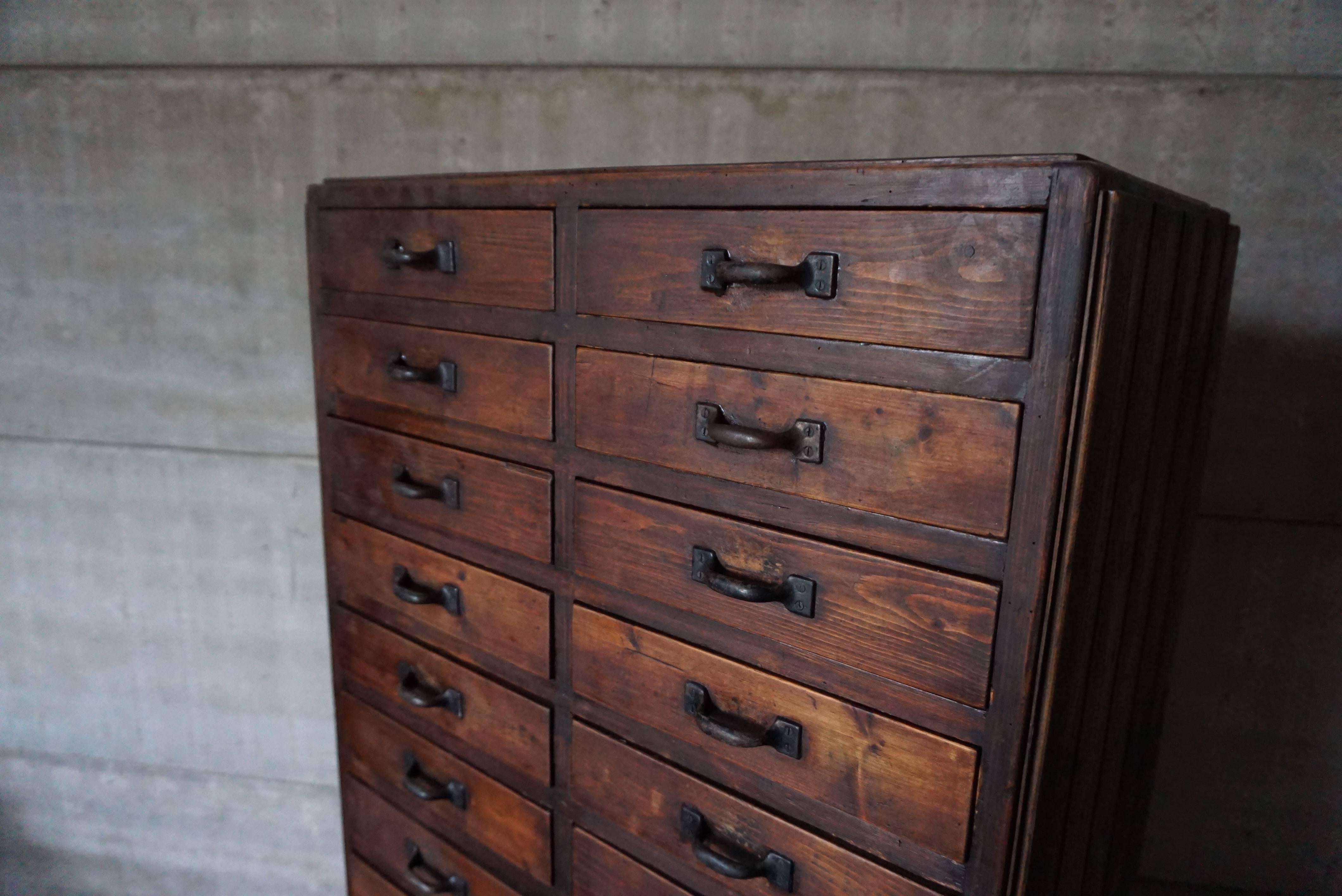 This industrial workshop cabinet was designed during the 1920s and manufactured in the Netherlands, where it was used in a factory. It is made from pinewood and features 28 drawers, some with dividers some without. This item remains in a good