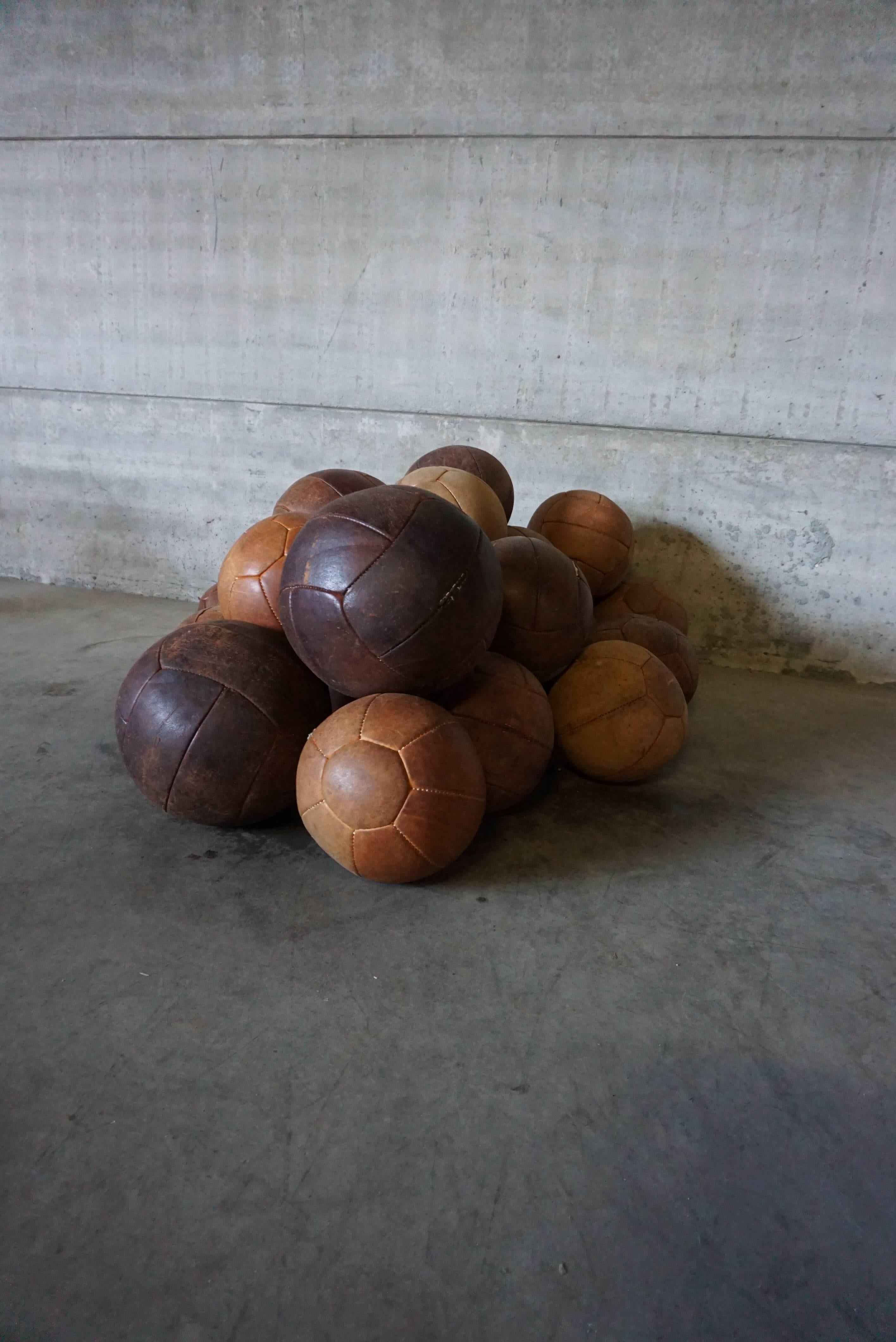 A nice collection of 25 1940s European exercise balls. Ranging in size and color tones of brown, beige and cognac, these items would make an excellent collection or a Stand alone object d'art. The leather has a nice patina.
