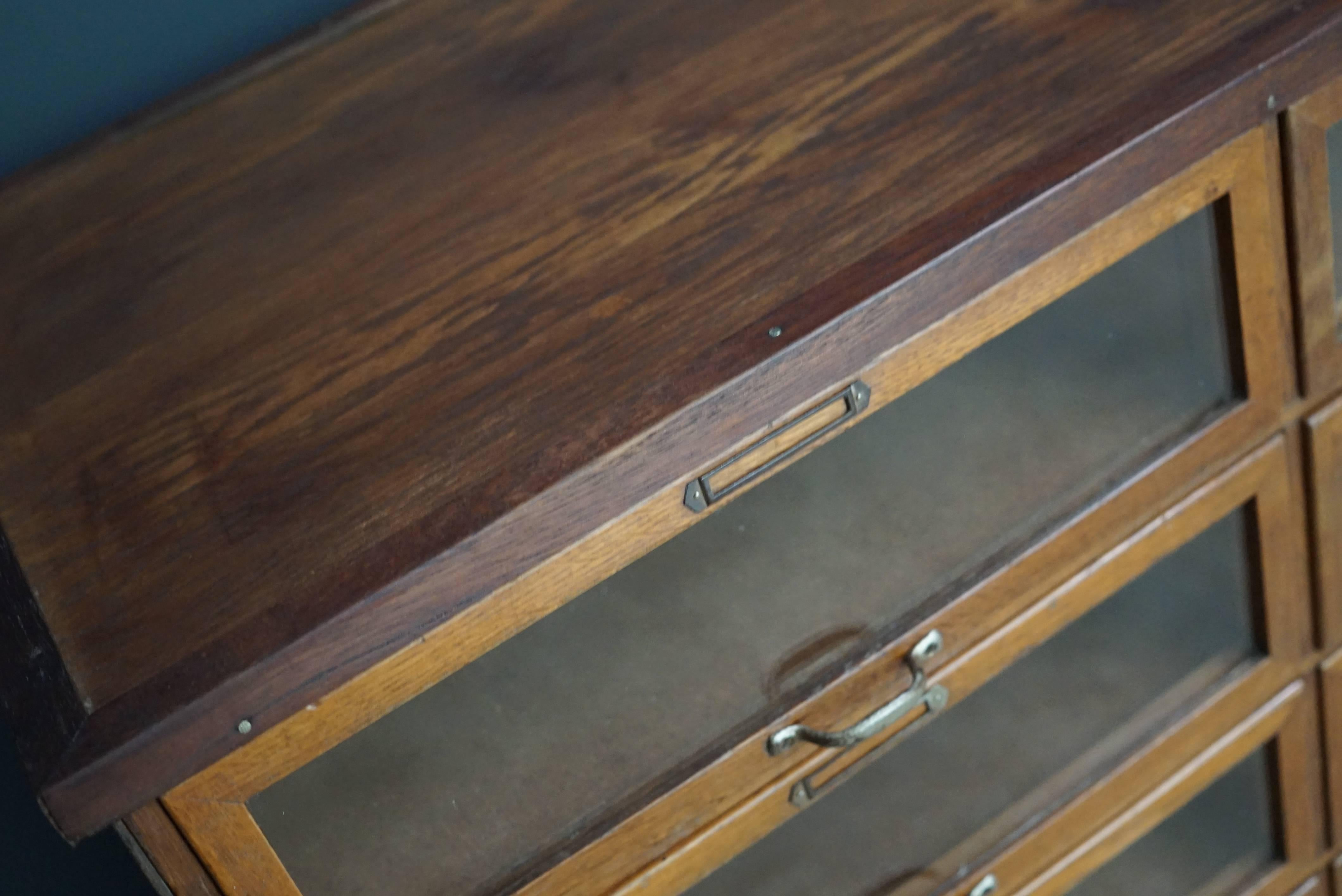 This vintage haberdashery shop cabinet originates from the UK. It is made from wood and features clear glass fronted drawers. The cabinet is in a good vintage condition with the drawers opening and shutting smoothly.