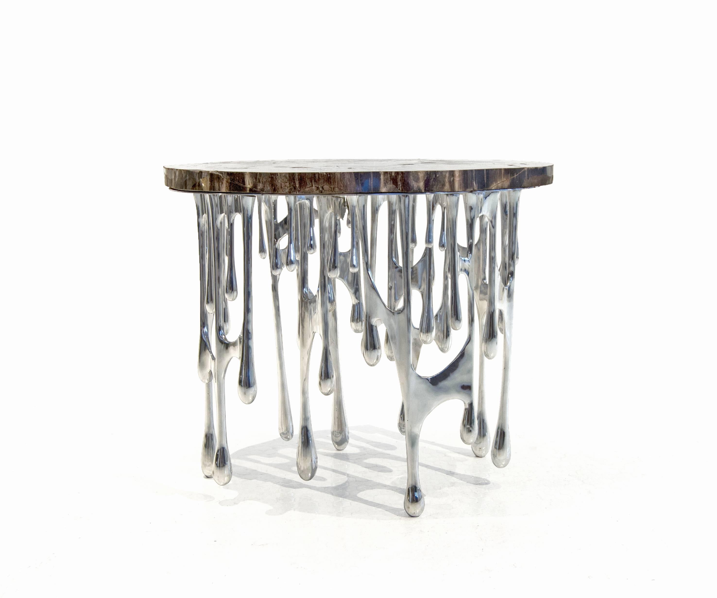 The Dripping Table merges zinc (a product of our techtonic era) and petrified wood (a timeless material).  The melting and dripping zinc symbolizes the emergence of a new world.

The Dripping Table is part of the Morphogen series by John Brevard,
