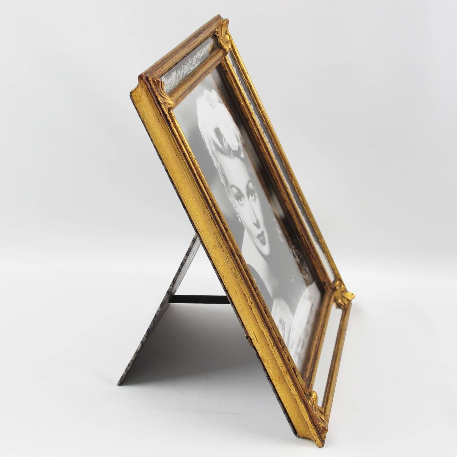 Vintage French gilded carved wood picture photo frame. Very nice dimensional shape with mirror parcloses. Fine vegetal carved patterns. Printed paper back and easel, circa 1950s.

Measurements: 
Overall: 9.44 in. wide (24 cm) x 11.82 in. high (30