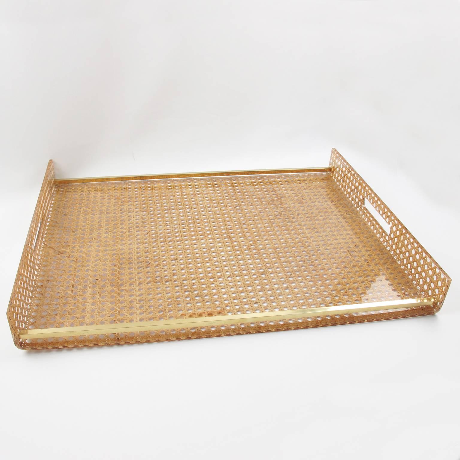 Elegant large butler serving tray made of Lucite and Rattan designed for Christian Dior Home Collection in 1970s. Geometric shape with gilt brass gallery and real rattan cane-work embedded in the crystal clear Lucite. Great accessory for any modern