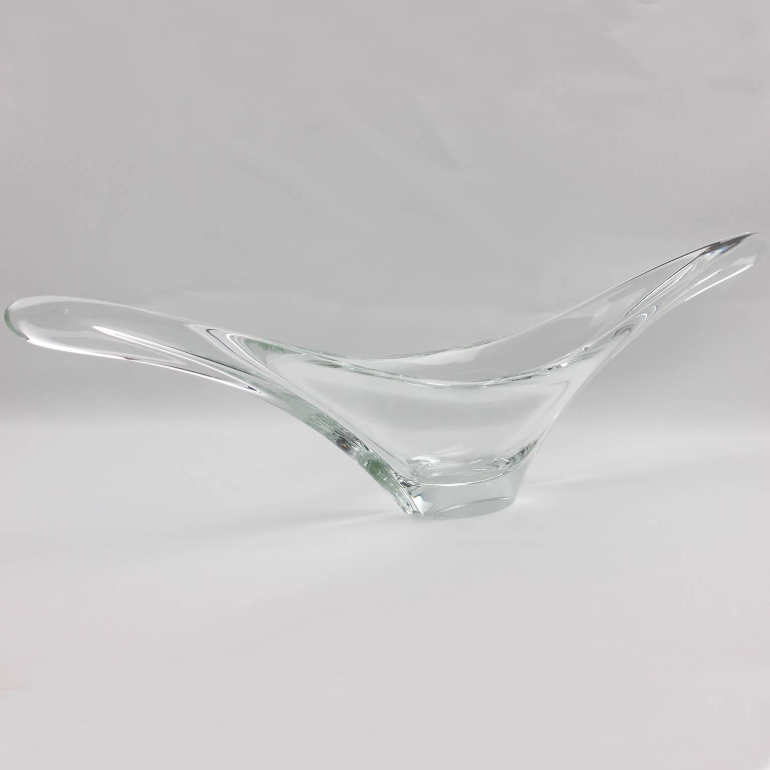 Impressive sculptural clear crystal centerpiece bowl or vase by Daum, France, circa 1950s. Typical Daum Mid-Century Modernist elongated abstract design, and although thick and heavy, this piece has a smooth and light shape. Etched signature of Daum