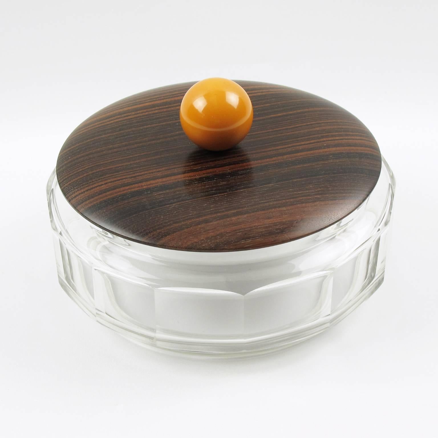 Elegant vintage French Art Deco decorative cookie box, candy jar, circa 1930s. Modernist round design with large dimensions. Crystal cut bowl with large geometric etching all around, topped with Macassar Ebony wood lib ornate with large round bead
