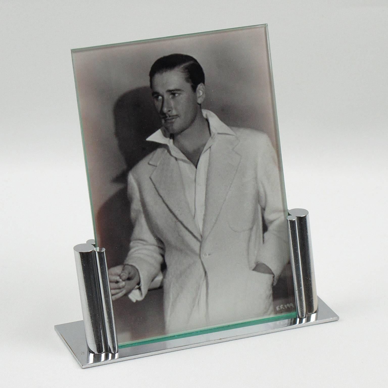 French Art Deco picture photo frame. Architectural all chrome shape with flat rectangular base and two vertical frame supports with geometrical detailing. The two supports hold one piece of glass on the front and one sheet of metal at the back which