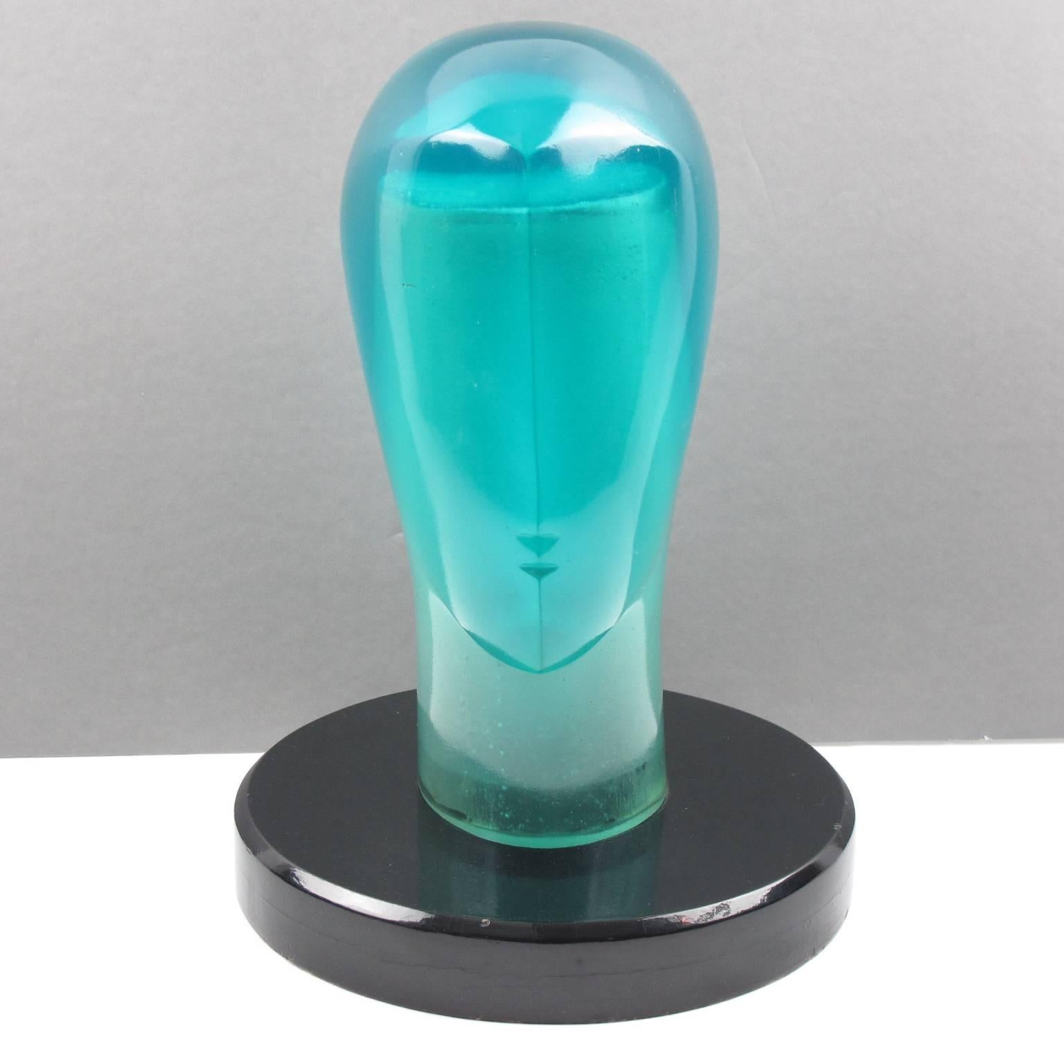 Spectacular huge resin head model or sculpture, probably a store display stand, circa 1970s. Unique aqua turquoise blue all translucent color with Minimalist almost Art Deco design carved face. Solid wood base with black lacquered finish. Note, the