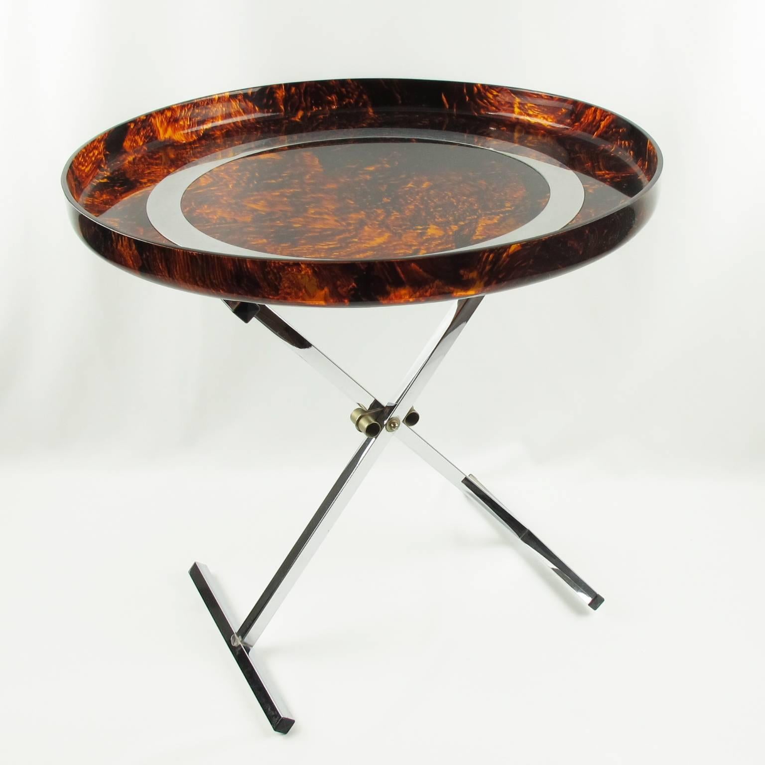 Lovely modernist folding tray table, circa 1980s. Extra large round shape butler tray with turned-up edges and central large chromed metal band inlaid. Thick Lucite with faux tortoiseshell color. Chromed metal folding X-stand. Perfect for barware,
