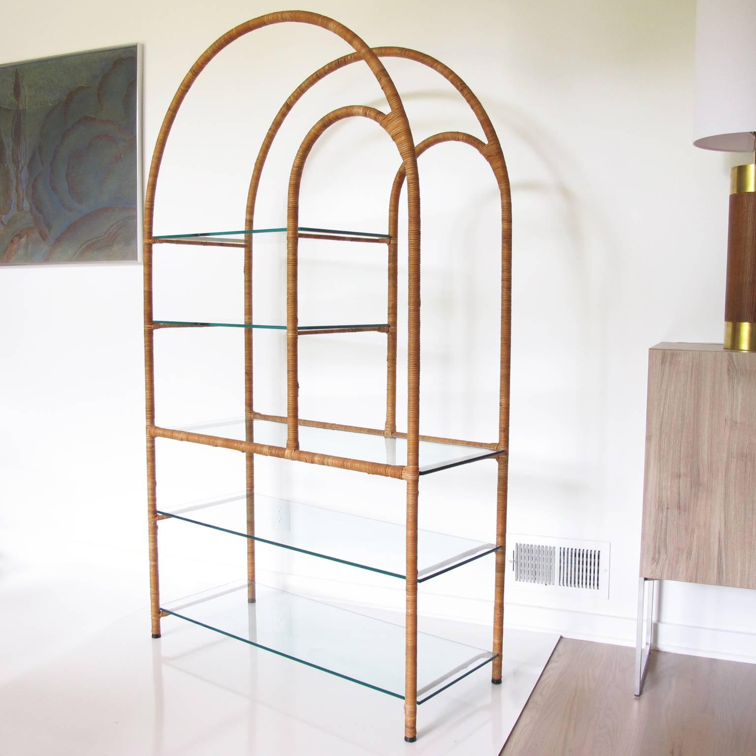 Striking Mid-Century modernist display shelf makes an ideal storage piece for a large variety of interiors. Most likely by Milo Baughman, this elegant Hollywood Regency étagère or bookcase is sculpturally designed with rattan or wicker wrapped