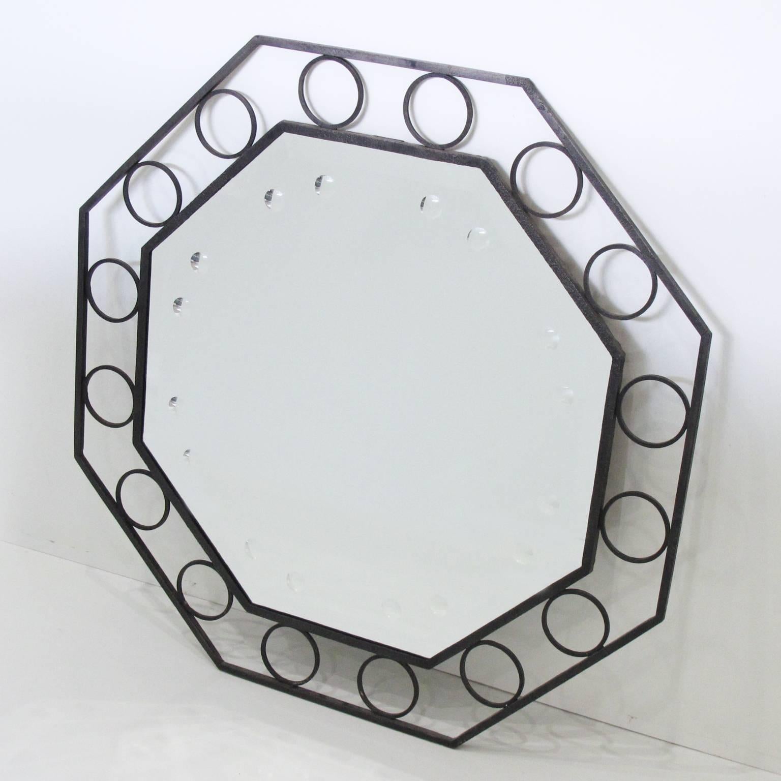 Vintage French Mid-Century modernist cast iron wall mirror, circa 1950s. Large octagonal shape with elegant cast iron frame with original black patina. Mirror insert ornate with optic bullseye motifs. Excellent vintage condition.

Measurements: