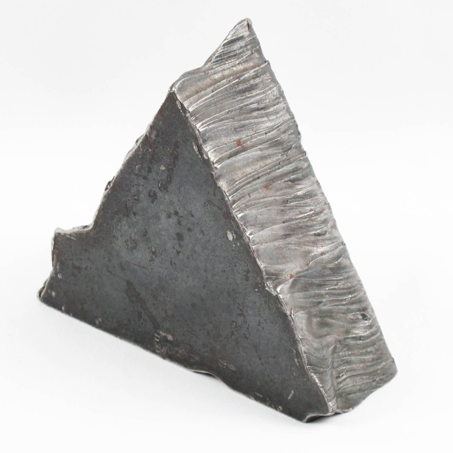 Vintage Industrial geometric raw stainless steel object that would make an excellent paperweight on a desk. Interesting triangle shape (can be used in upright position or flat) with sculptural carved edges. Very good vintage