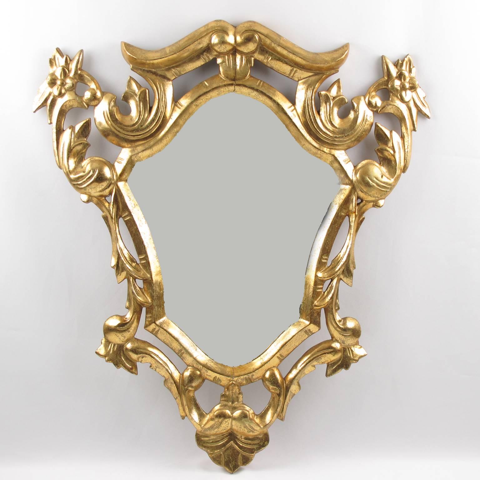 Elegant early 20th century French giltwood mirror in a Louis XV Rococo style. Hand-carved and gold leaf frame with elaborate pierced and see thru floral design. Original mirror reflector is useful throughout the surface. Gold leaf in good vintage