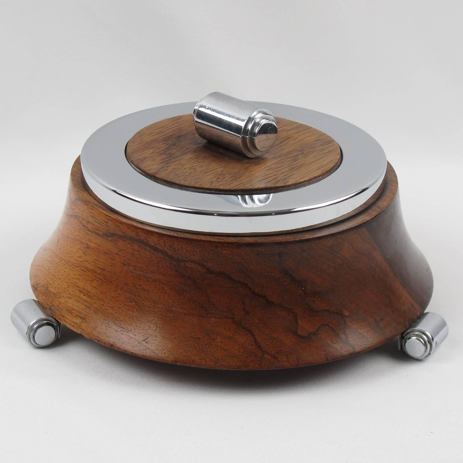 Elegant vintage French Art Deco decorative lidded box, probably a jewelry box. Rounded design with chromed metal lid, finial and tiny feet, body in walnut with carved shape. Interior with beige velvet liner, circa 1930s. Very good vintage