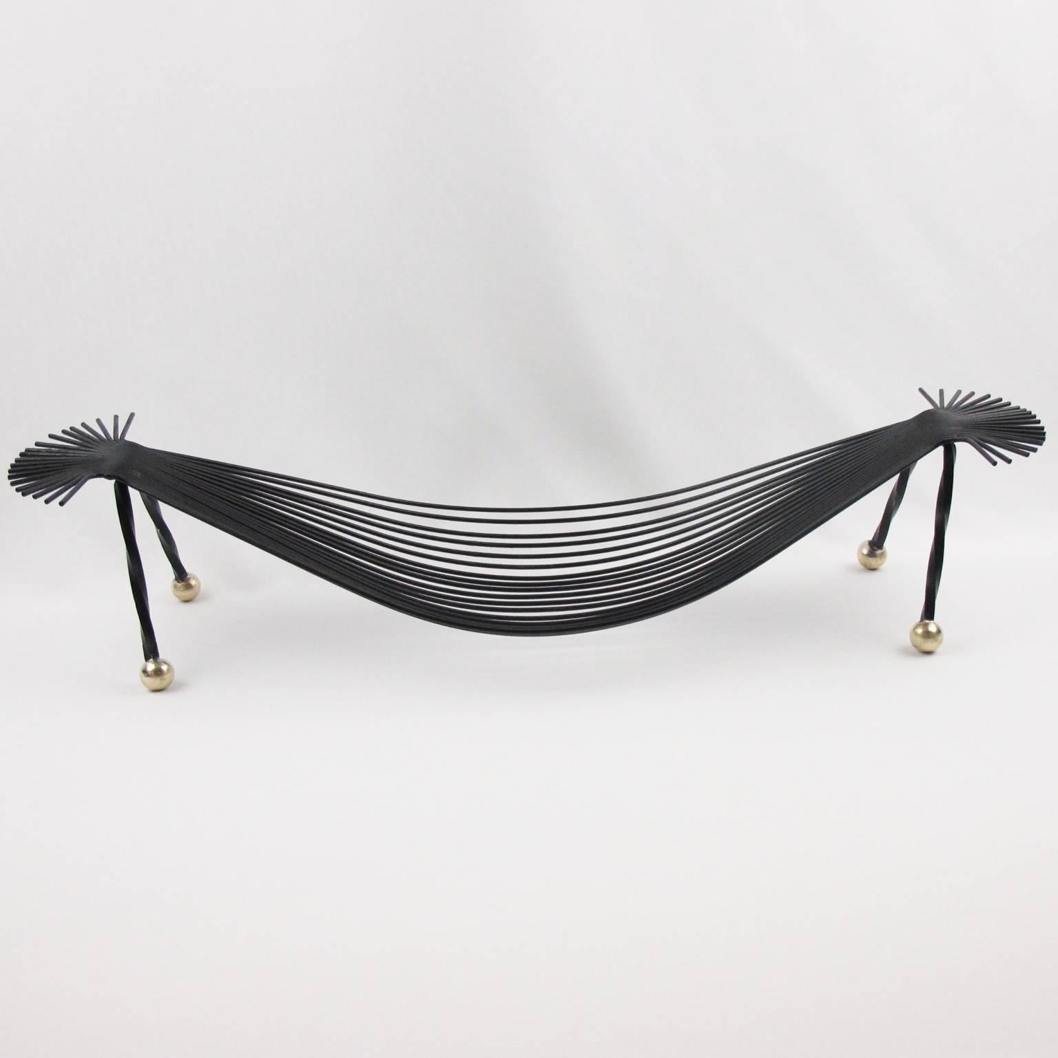 Stunning Mid-Century Modernist metal fruit bowl or basket, France, circa 1960s. Original black paint patina with polished brass bead feet. Elongated hammock shape with thin metal rods. No visible marking. Excellent vintage