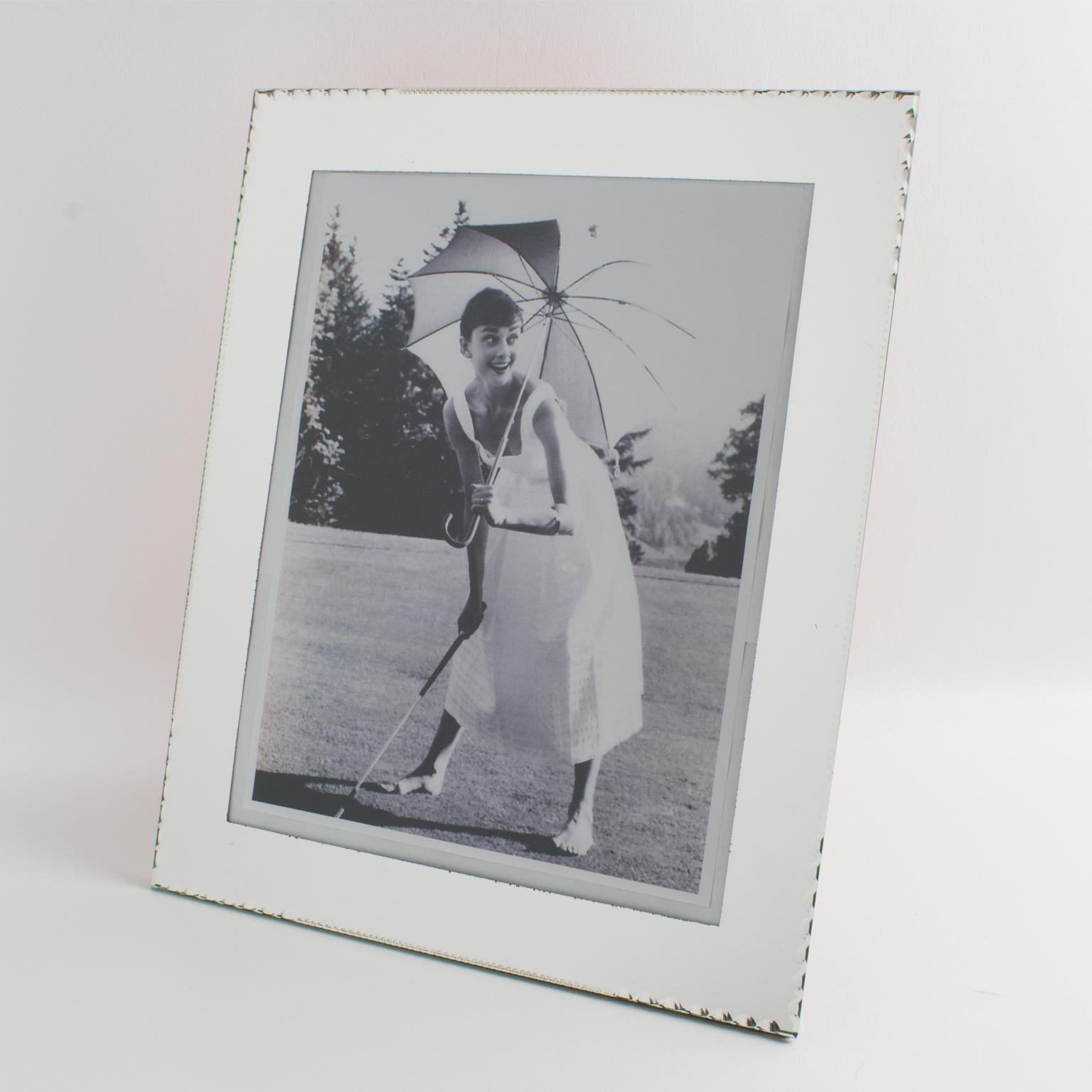This stunning French mirrored glass picture frame has lovely silver mirror-beveled edges with a deep geometric design. You can arrange the photo frame in either a portrait or landscape orientation. The back and easel are on cognac paper with a