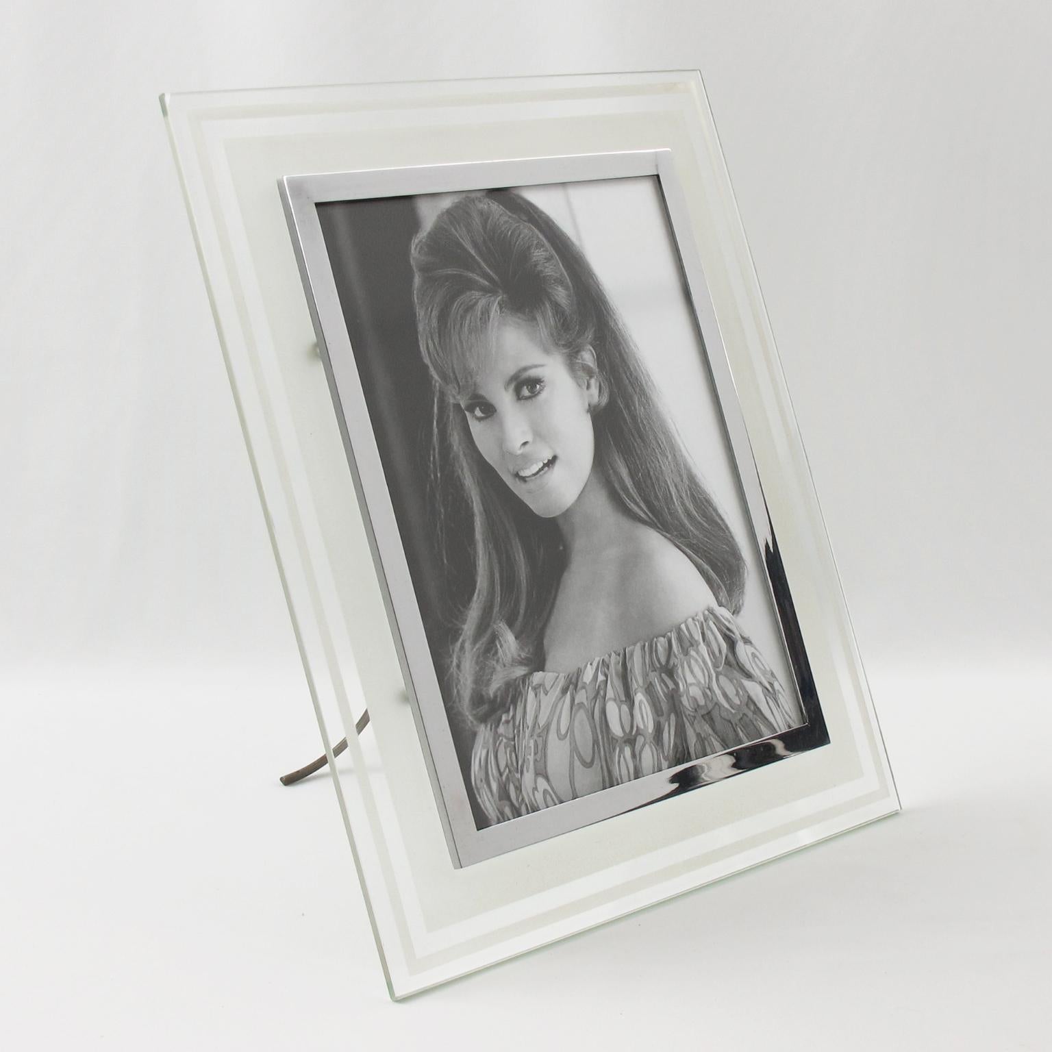 This stunning French glass picture photo frame features a transparent and frosted glass slab with a geometric design and refined chromed metal framing, surrounding the picture view. A metal easel at the back keeps the frame upright. There is no