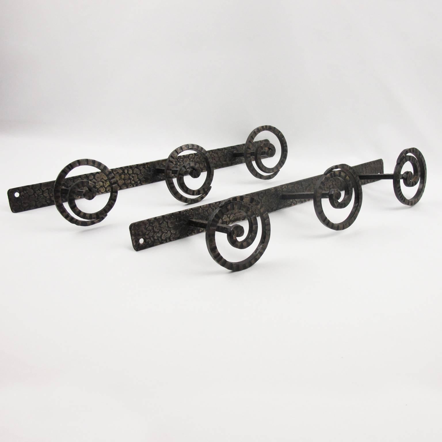 Elegant set of two French Art Nouveau wall mounted wrought iron coat racks. Original black patina with hammered textured finish. Three rounded coat hooks on each rack. 
This item is sold as a pair, however if you are interested in only one rack