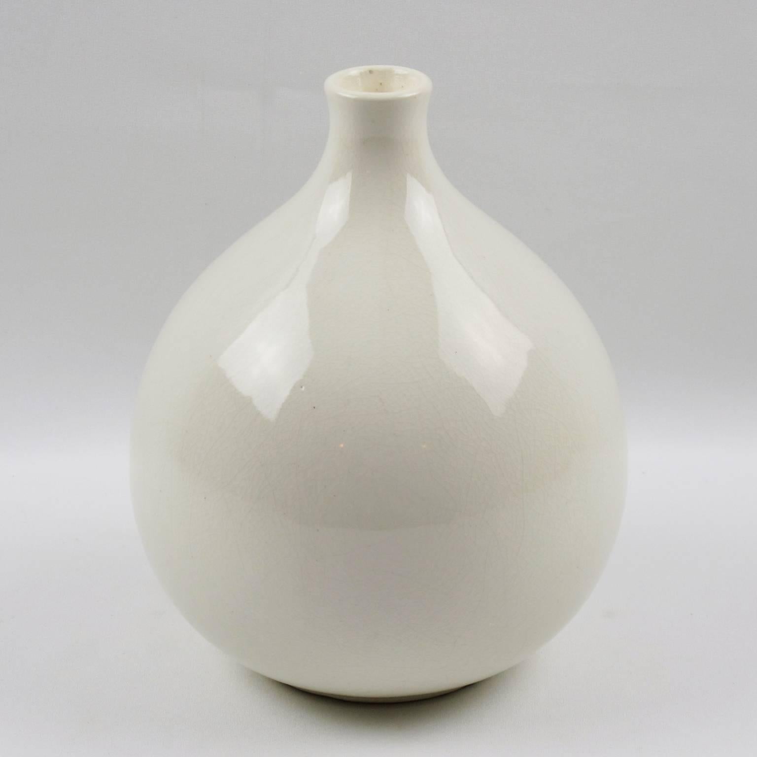 Elegant Art Deco vase by Saint Clement, France. French ceramic vase with white crackle glaze finish. Features a large puffy round shape with tiny narrow tube opening and Minimalist shape. Signed underside: 'St Clement - Made in France'.
The crackle
