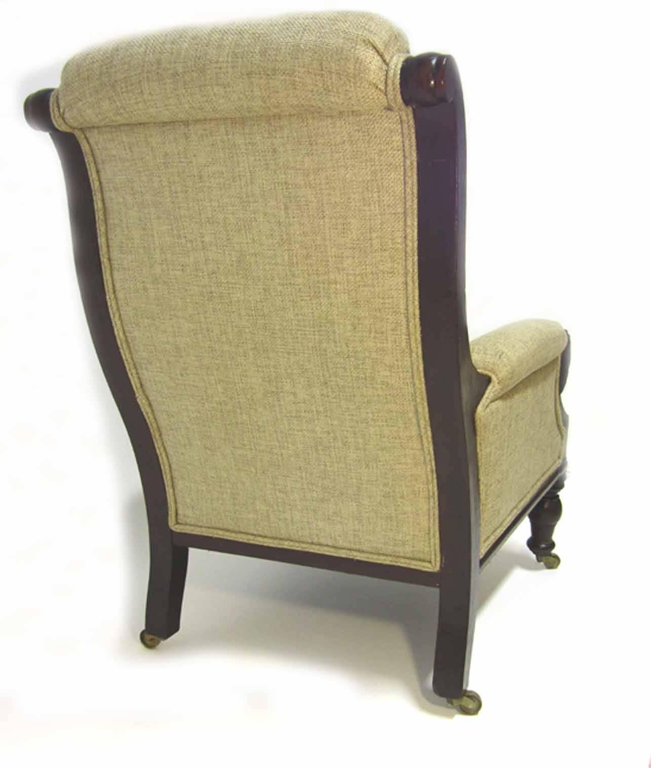 Bergere with a rolled cresting, the canted back flanked by finger moldings, upholstered arms with lion's head terminals, upholstered seat raised on bobbin-turned legs with brass casters, circa 1850.