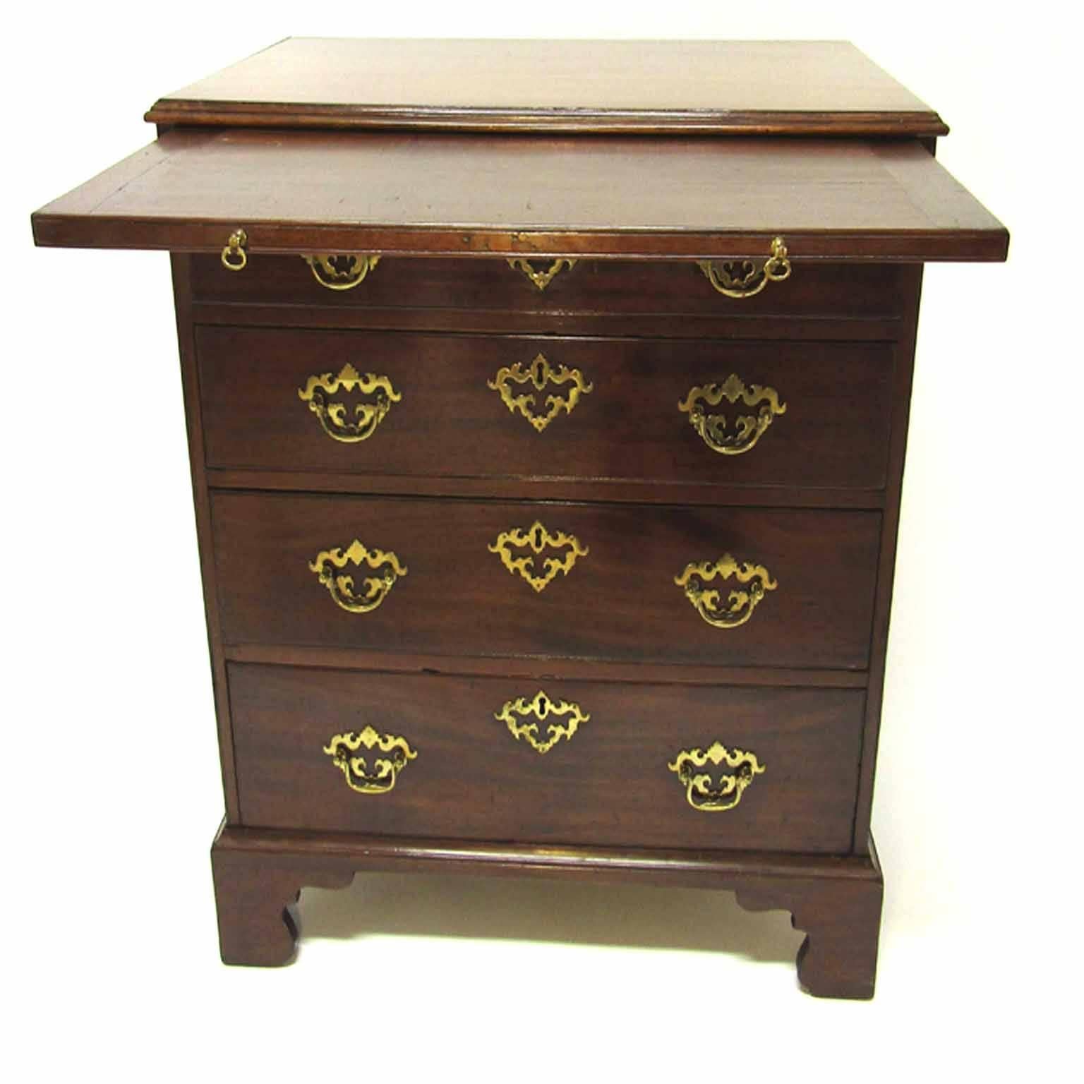 Bachelor's chest of rectangular from with a shaped edge over a brushing slide, over four graduated drawers having original brass pierced bail handles and side handles, raised on bracket feet, circa 1760.