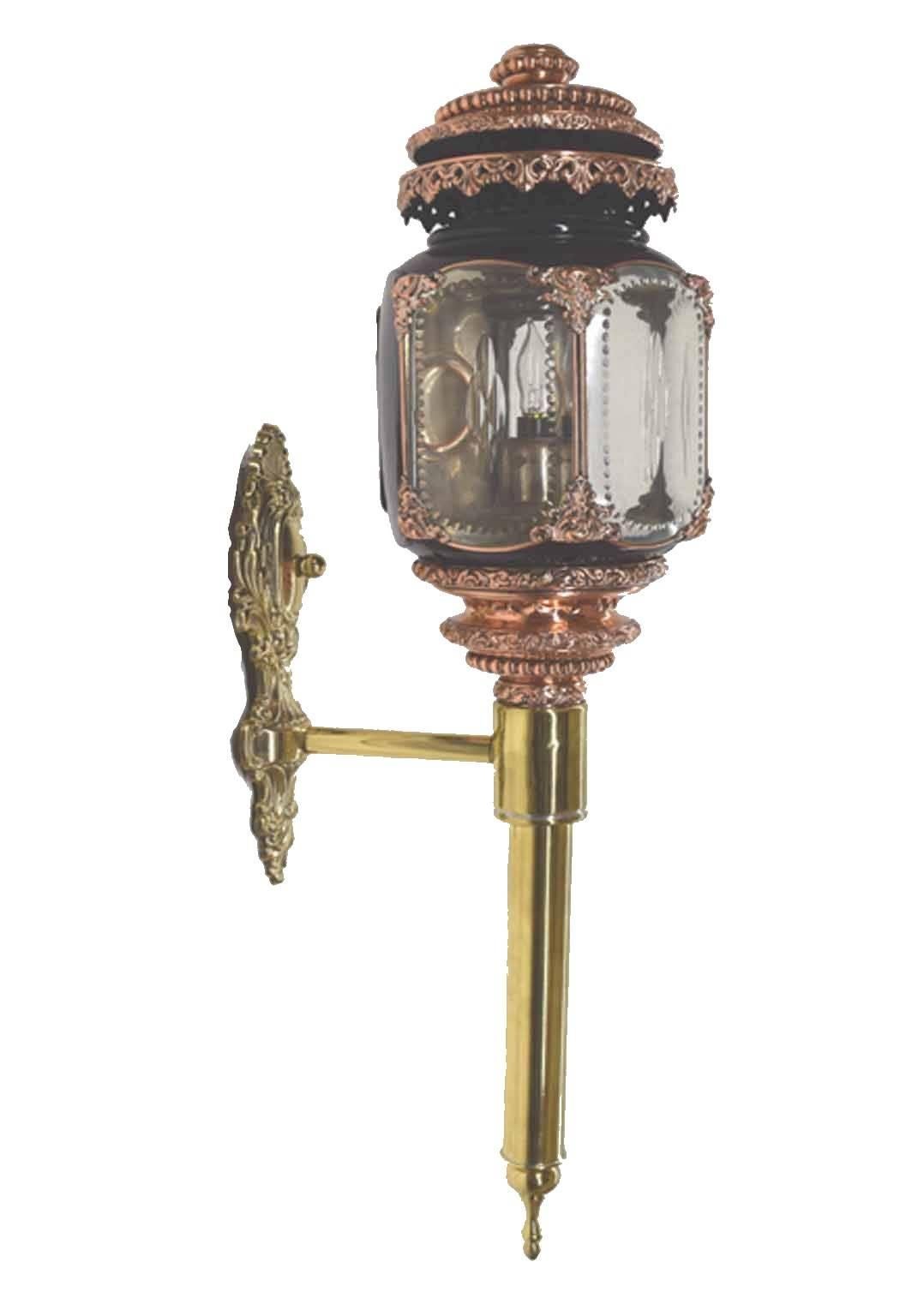 Antique English brass, copper and black tole peinte carriage lamps of large size; topped by a copper dome over a hexagonal cut and beveled glass nickel silvered light cage, over a floral repousse and beaded copper standard ending in a brass tapering