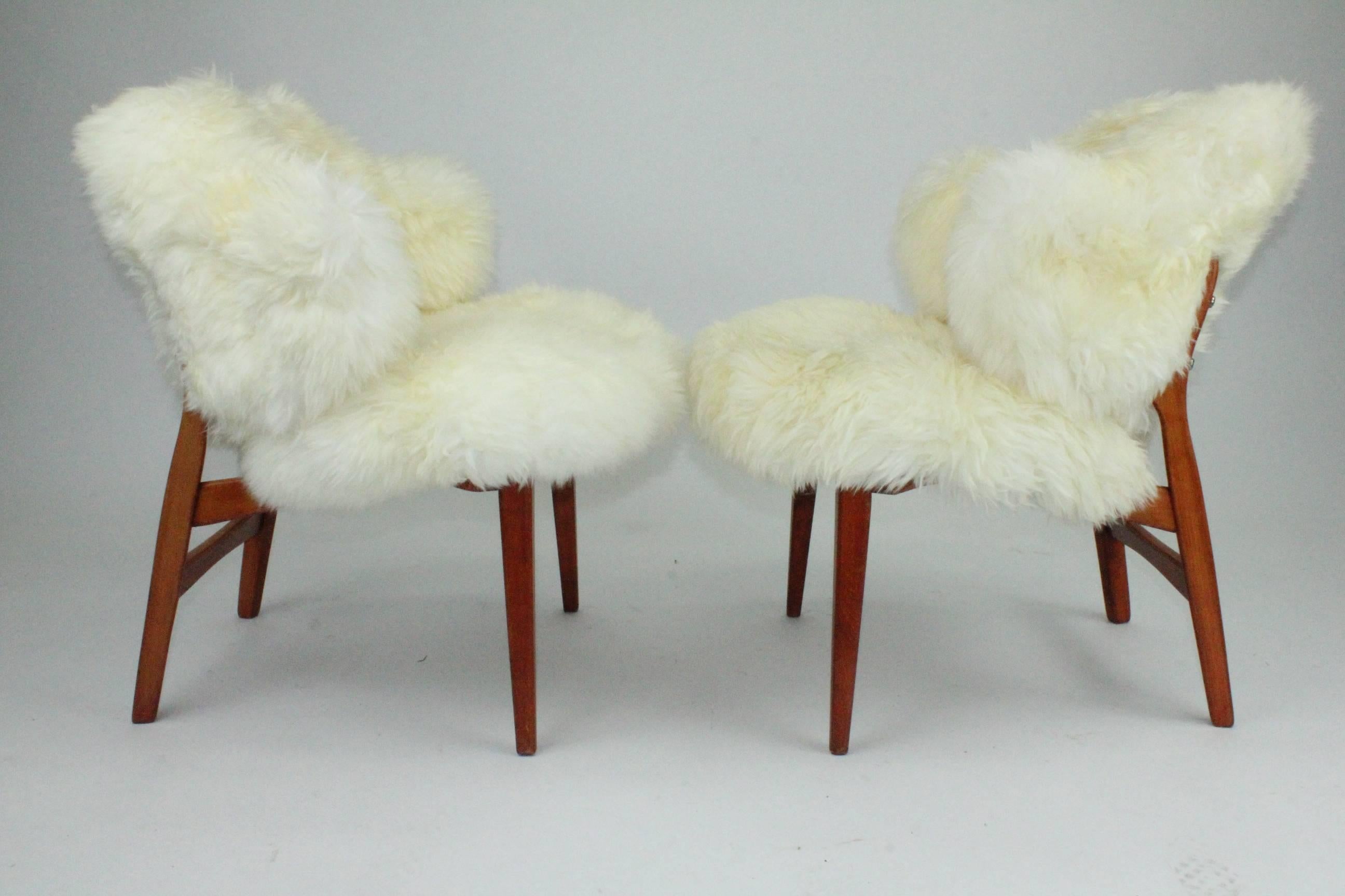 A pair of Danish 1960s shell chairs newly upholstered in long haired sheepskin. A wonderful pair in good condition. Comfortable and cosy.