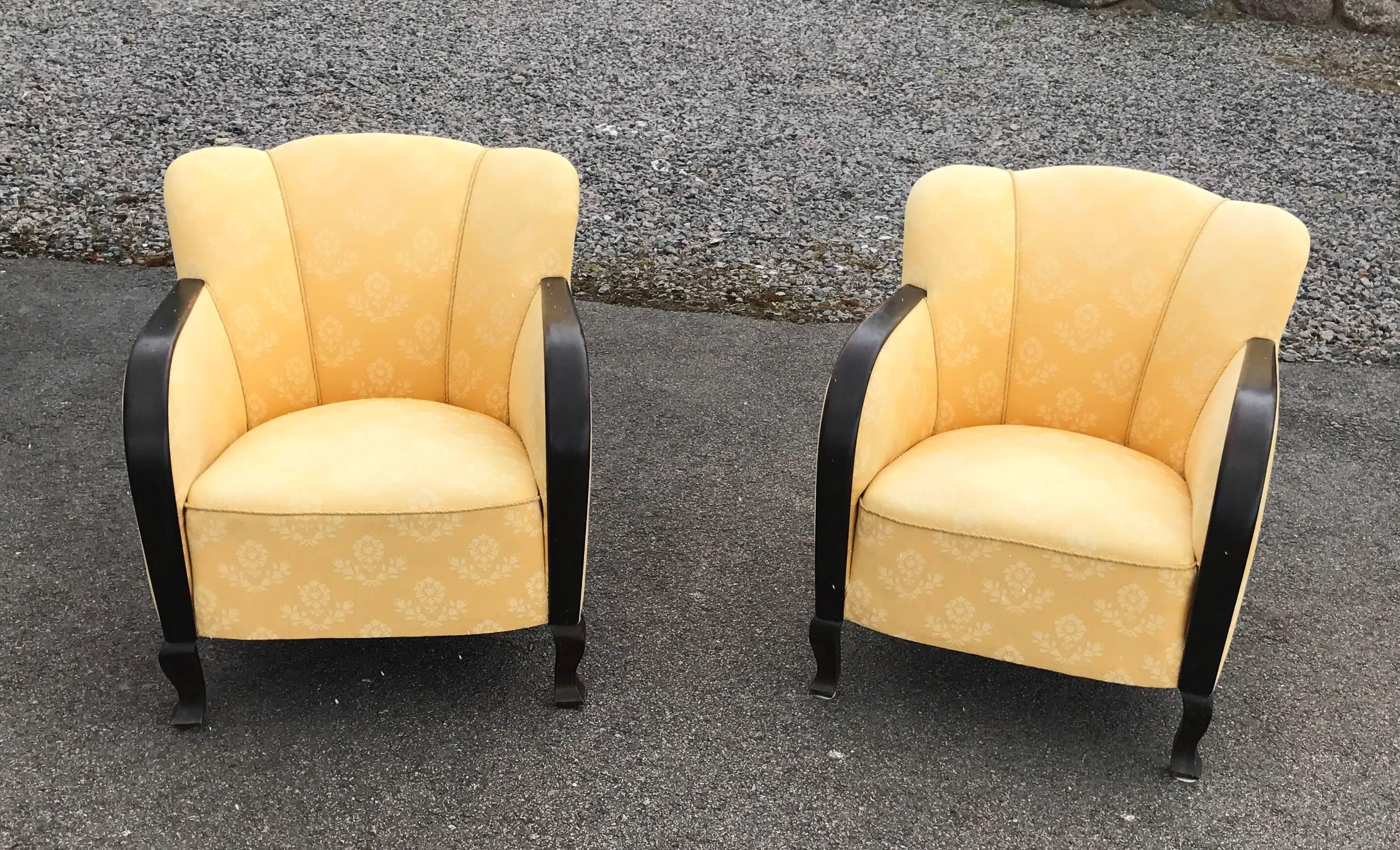 Sunny pair of Art Deco club chairs, with armrests and legs in stained birch. Shell shaped backs and a nice yellow fabric. 
Comfortable and nice chairs. 

We will be happy to reply on your questions.