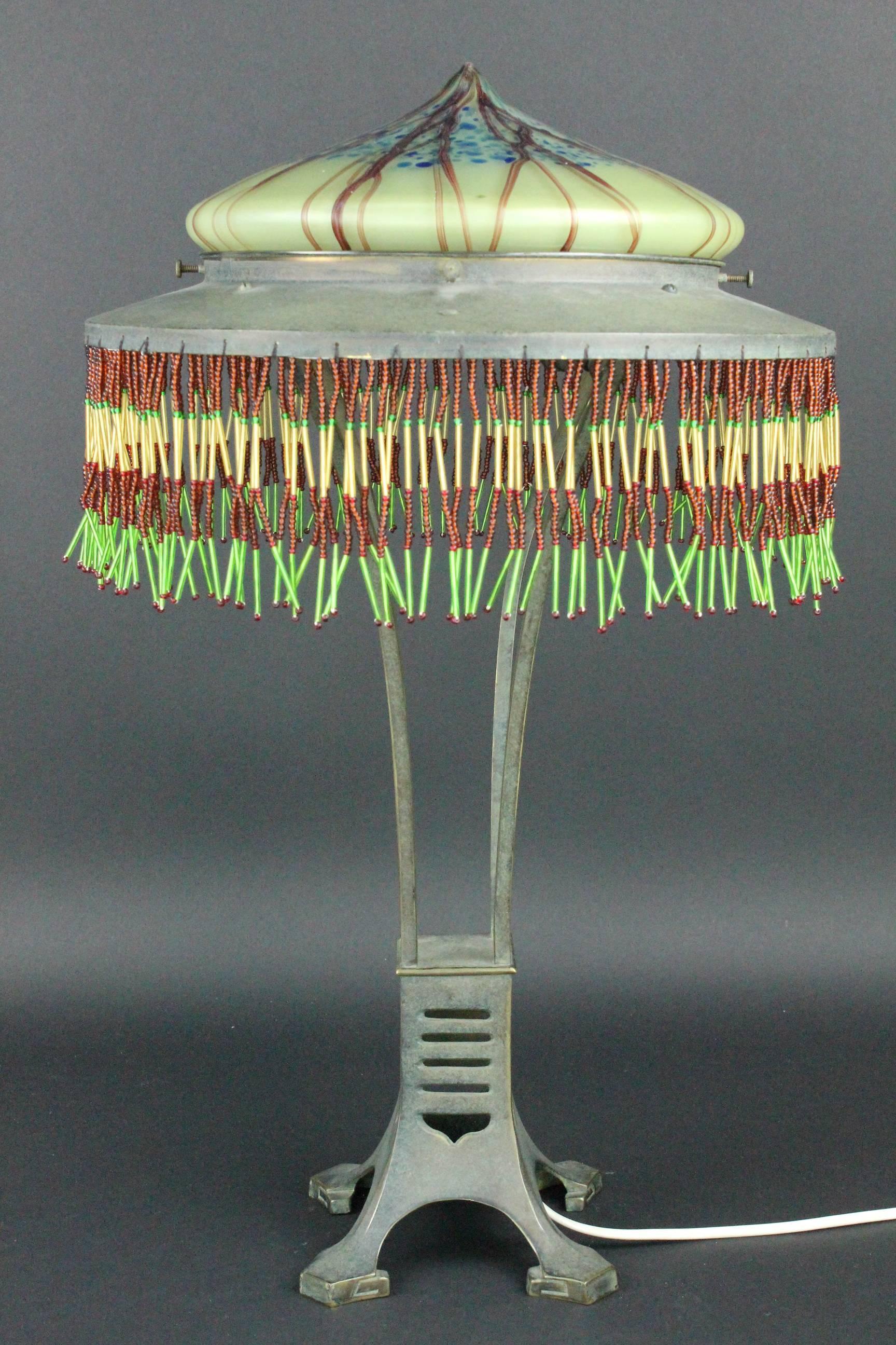Eine sehr ungewöhnliche und seltene Tischlampe. Österreichischer Jugendstil-Lampenschirm aus dem frühen 20. Jahrhundert.
Grün patinierte Bronze. Schöner Originalzustand. Der Glasschirm mit kleinen Kerben. Diese kleinen Schrammen sind völlig