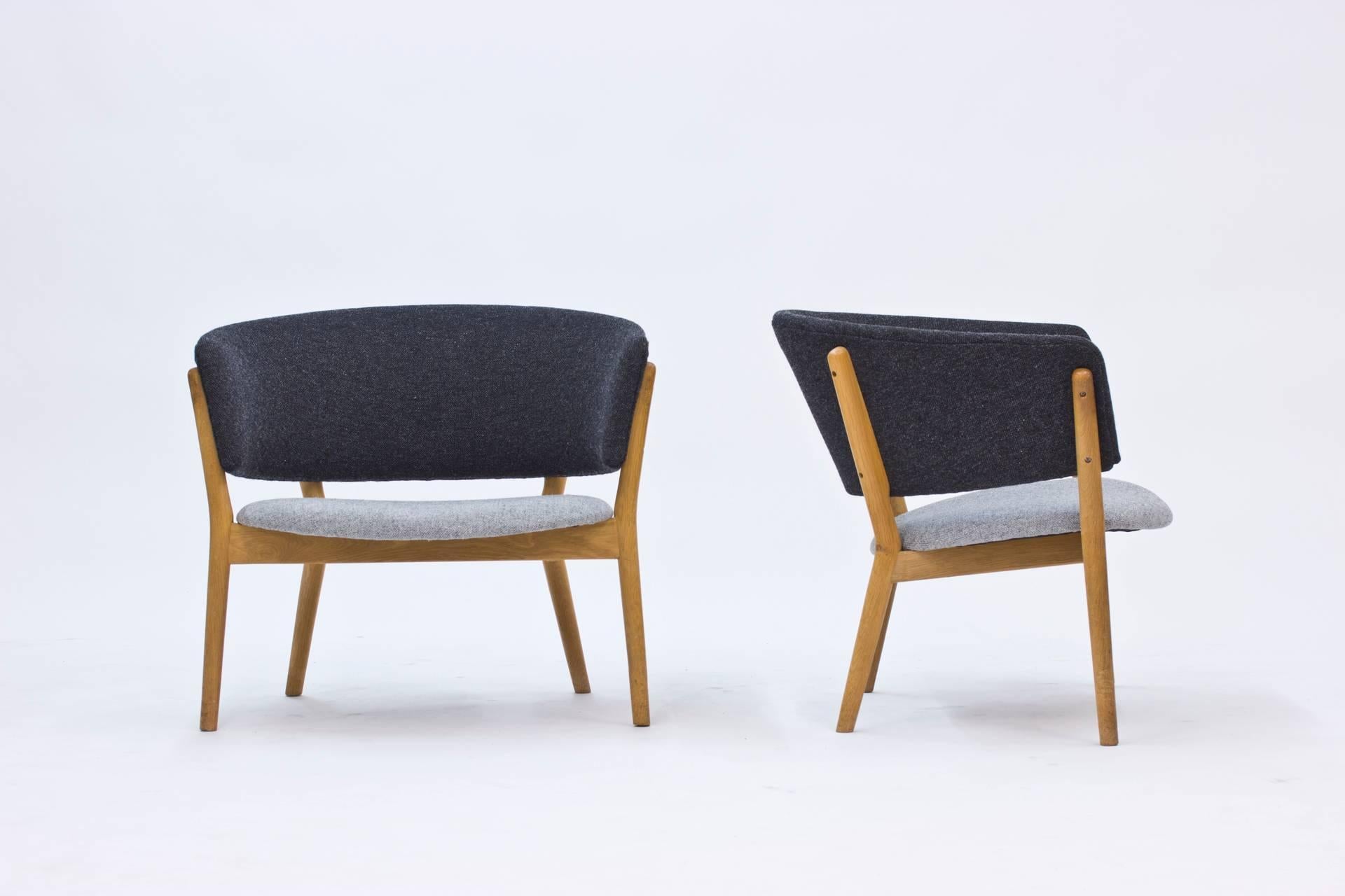 Pair of lounge chairs by Denmark's First Lady of Design, Nanna Ditzel. Made of oak and re-upholstered with Kvadrat wool fabric. Very stable and in excellent condition.
