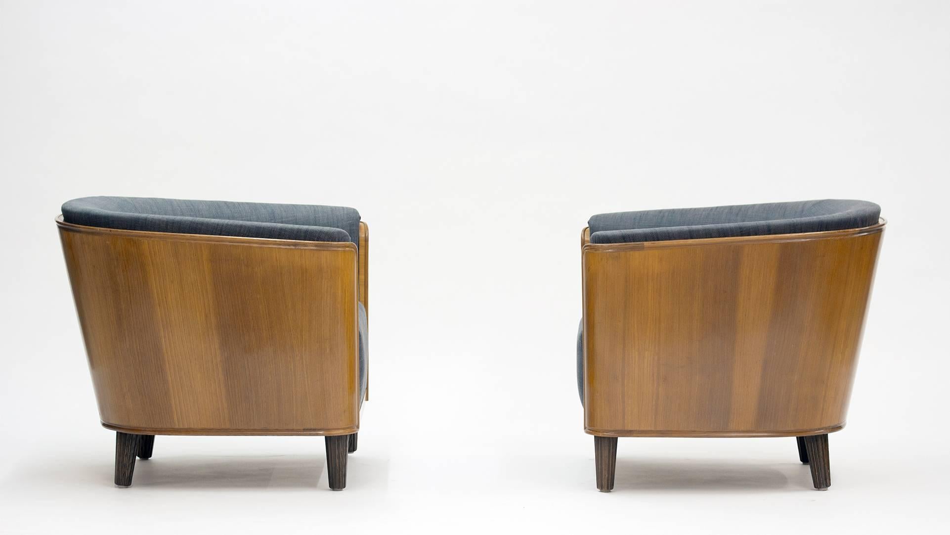 Pair of impressive 1930s lounge chairs by Oscar Nilsson with luxurious elm tree shells and modern blueish grey upholstery forming a perfect match.

Oscar Nilsson was an architect contemporary of Carl Malmsten and Axel Einar Hjort, designing