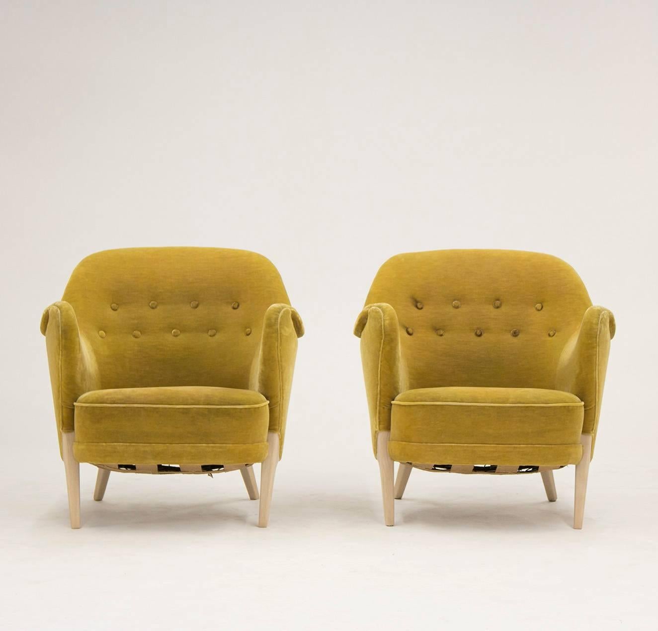 Pair of very rare lounge chairs by Arne Hovmand Olsen from the early 1950s. Awesome cheeky design with cool, angular legs and a luxurious extra seam running from under the armrests and up along the top. Original upholstery of a great color with some