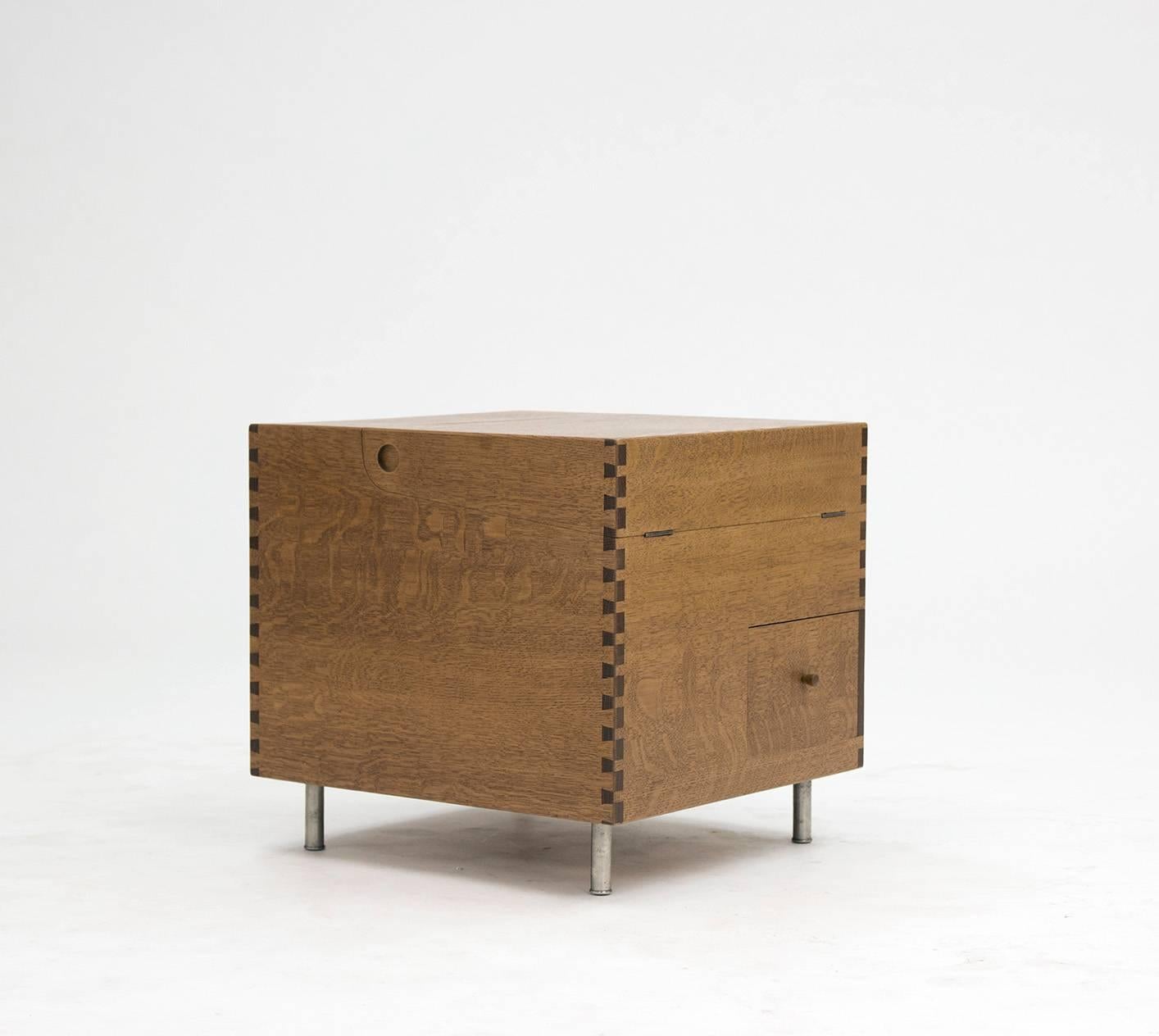 Amazing cubical bar cabinet, model "8034", by Hans J. Wegner. Made in oak with a striking pattern created at the joinery of the sections. Has one-drawer and two compartments inside. Original steel legs.
