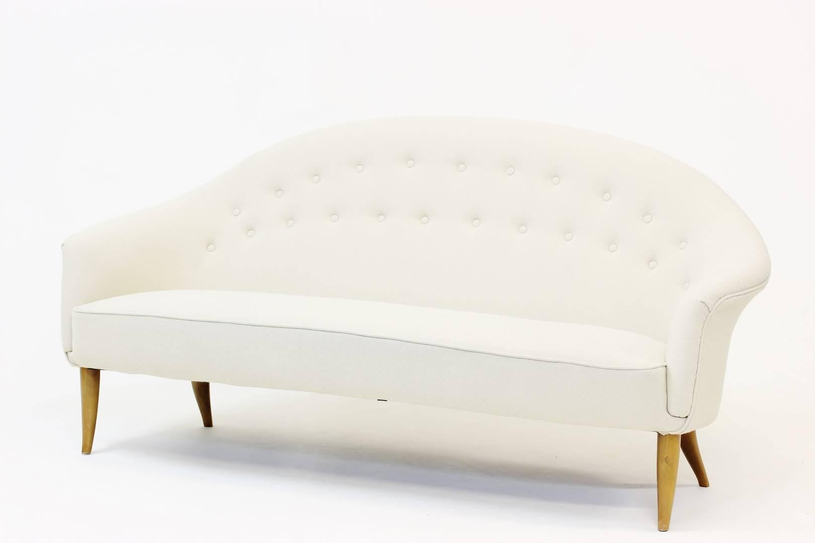 Elegant, feminine three-seat sofa from the “Paradis” series by Kerstin Hörlin-Holmquist for NK (Nordiska Kompaniet). Reupholstered with an off-white wool Hallingdal fabric.