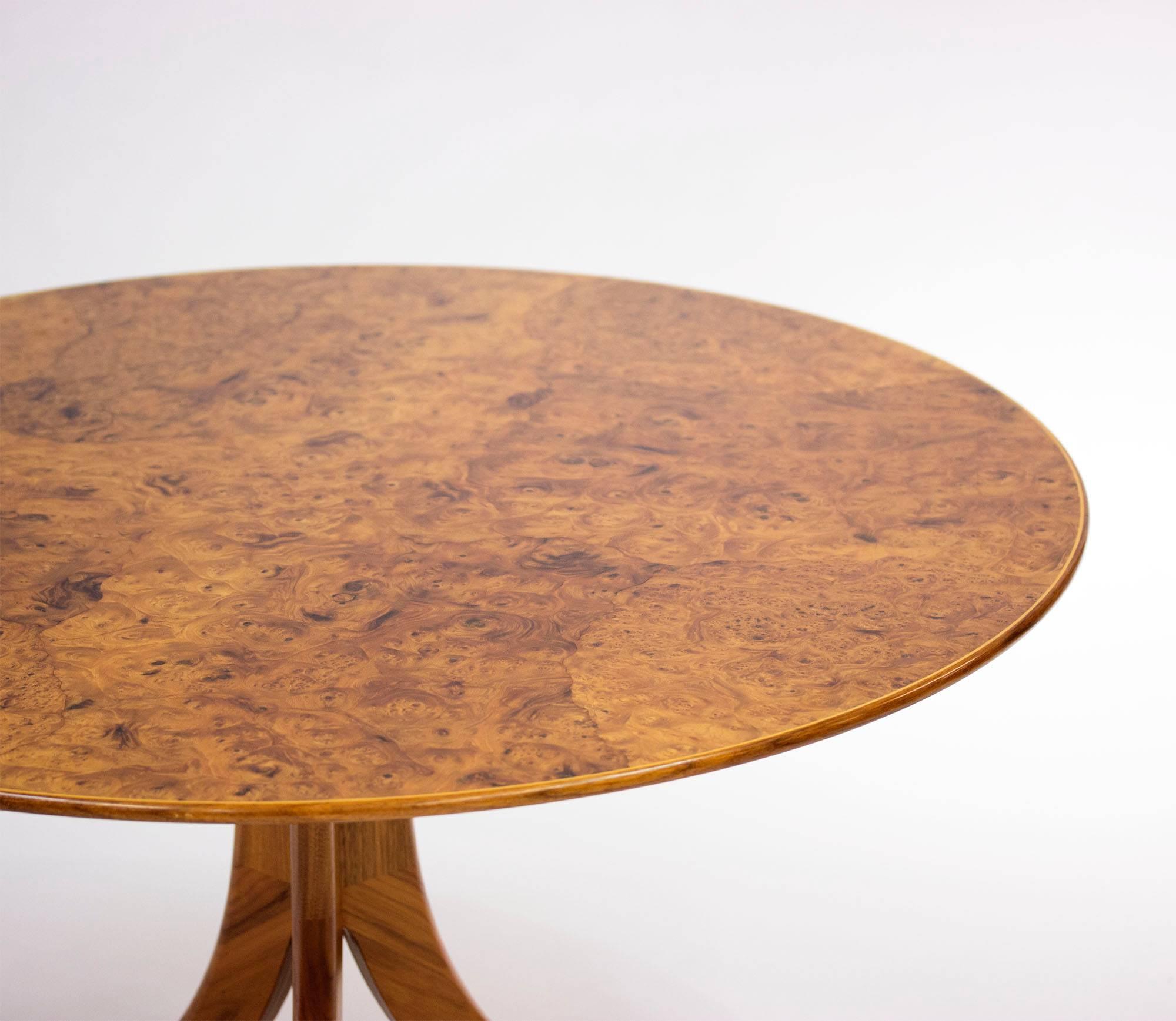Coffee table by Josef Frank for Svenskt Tenn, with a dazzlingly beautiful alder root veneer tabletop on three sculpted mahogany legs. This model has been produced over several decades with small alterations being made to the design, this is a