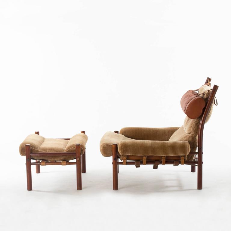Cool, slouchy “Inka” lounge chair with ottoman by Arne Norell. The cushions are supported by cut-out leather sections that are strapped to the frame and constitute an important part of the design. Original corduroy upholstery with neck cushion