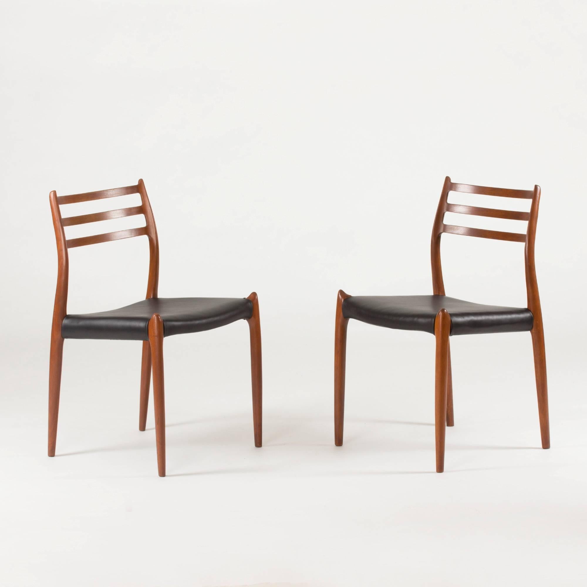 Set of eight beautiful dining chairs by Niels O. Møller, made of teak with black leather seats. Sculptural, hornlike details on the backrest and where the legs meet the seat. Wonderful quality, execution and comfort.