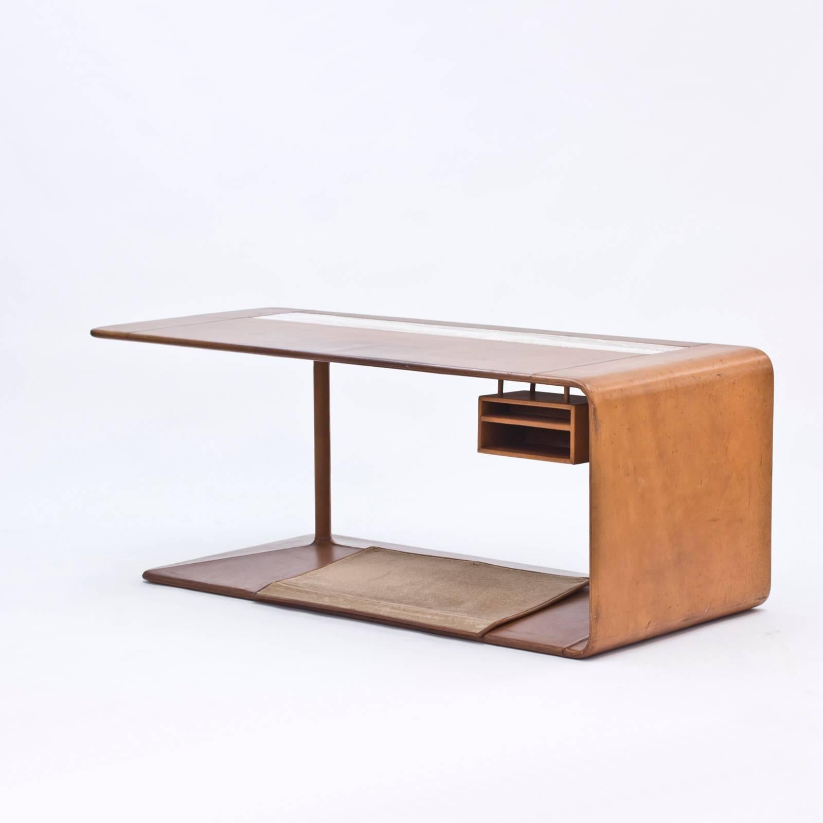 Absolutely stunning leather desk, custom-made by NK in 1965 for an interior in a private residence. The desk has been molded in fiberglass and entirely clad in high quality leather. On the top there is an inlay of off-white and brown-veined marble