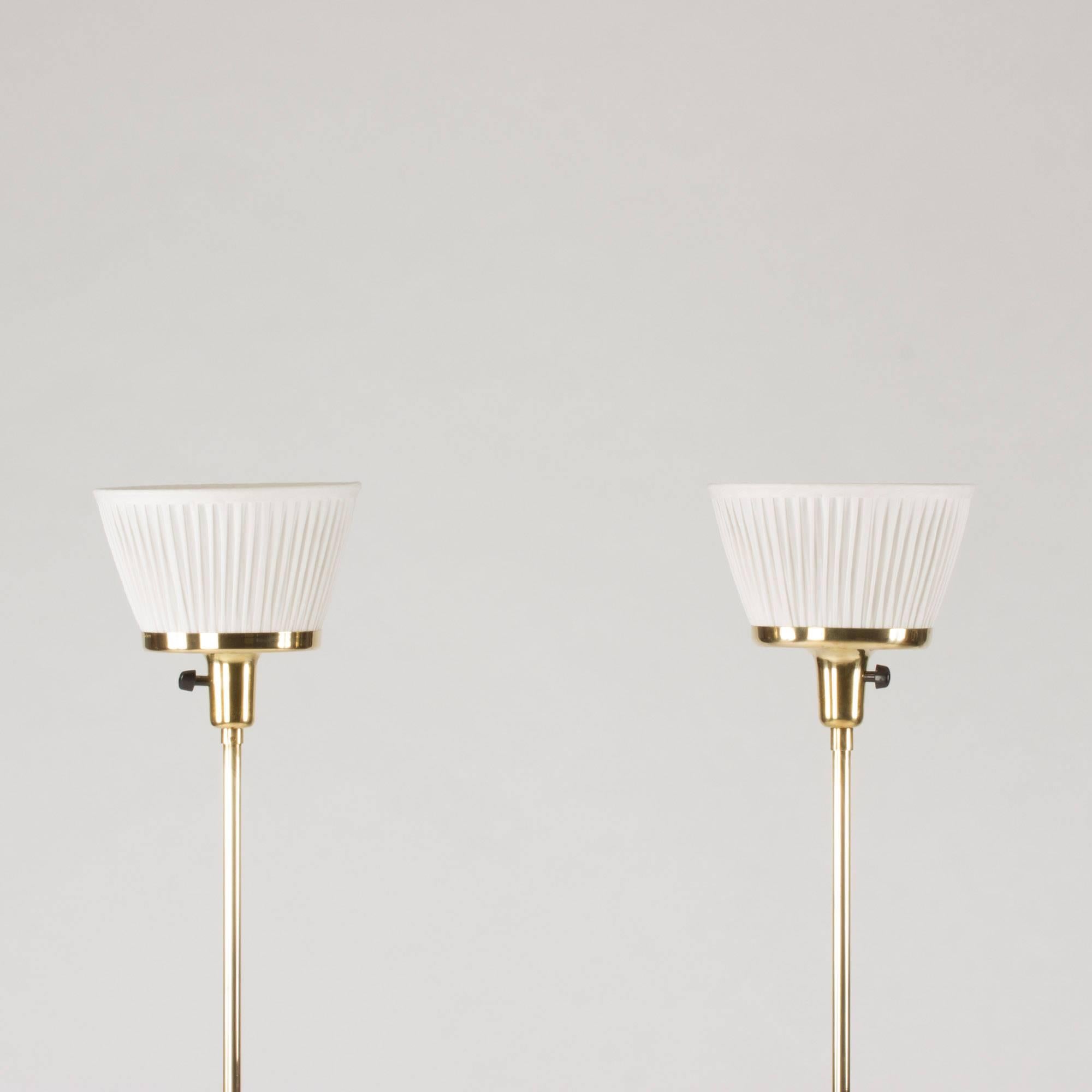 Pair of brass uplight floor lamps by Josef Frank. Beautiful, slender design with triple feet and cheeky, short linen shades.