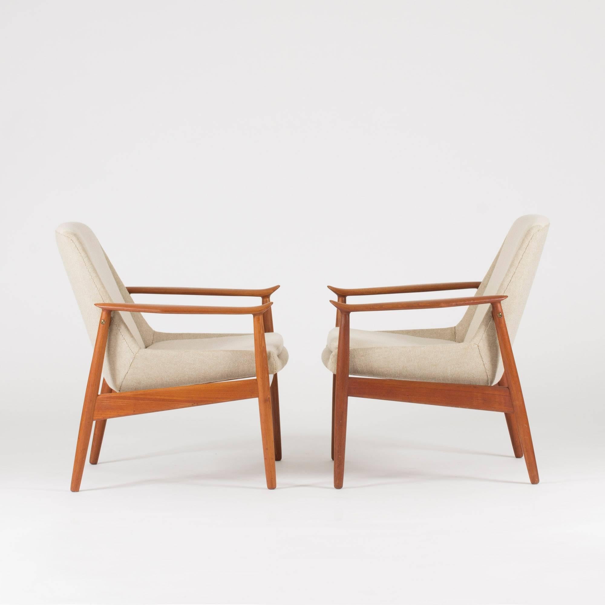 Pair of teak lounge chairs by Arne Vodder, with beautifully sculpted armrests. Upholstered with cream colored wool fabric.