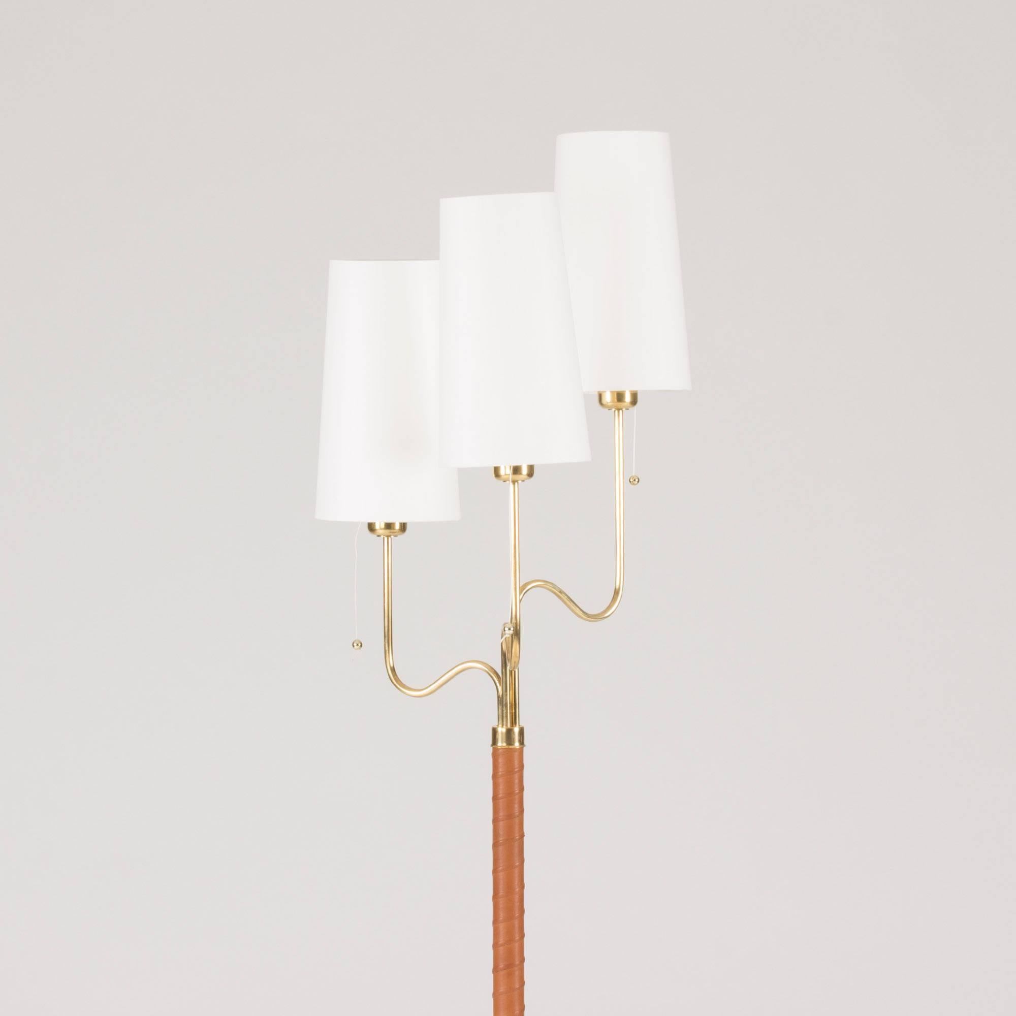 Luxurious brass floor lamp by Hans Bergström with a leather wound pole and three lamps shades set at alternating heights.