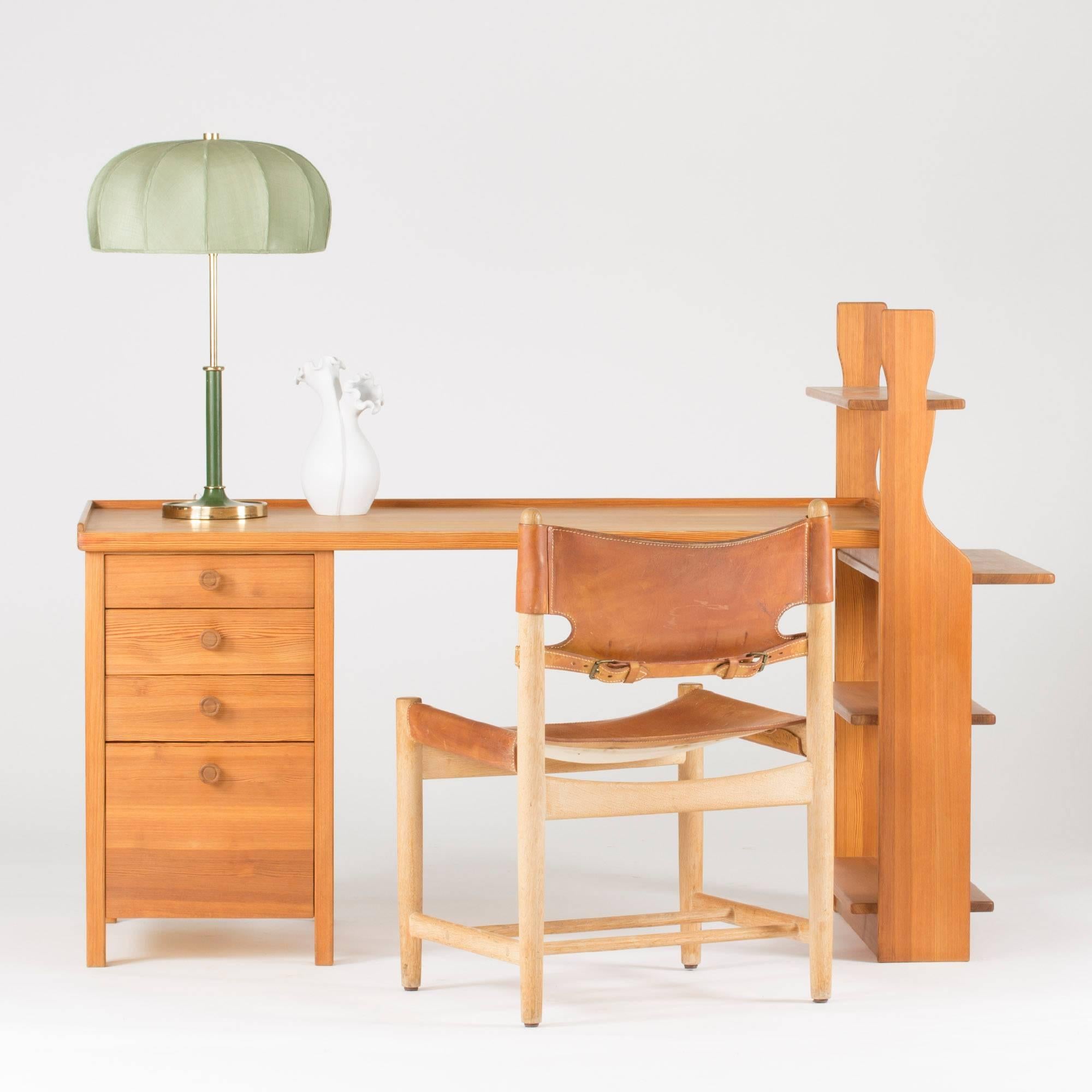 Rare pine desk, made by Carl Malmsten in the late 1930s. The desk is made from three separable modules; drawers, tabletop and shelves. Shelf sides made in a rustic, sculptural design. The tabletop is bordered on three sides by a slightly elevated