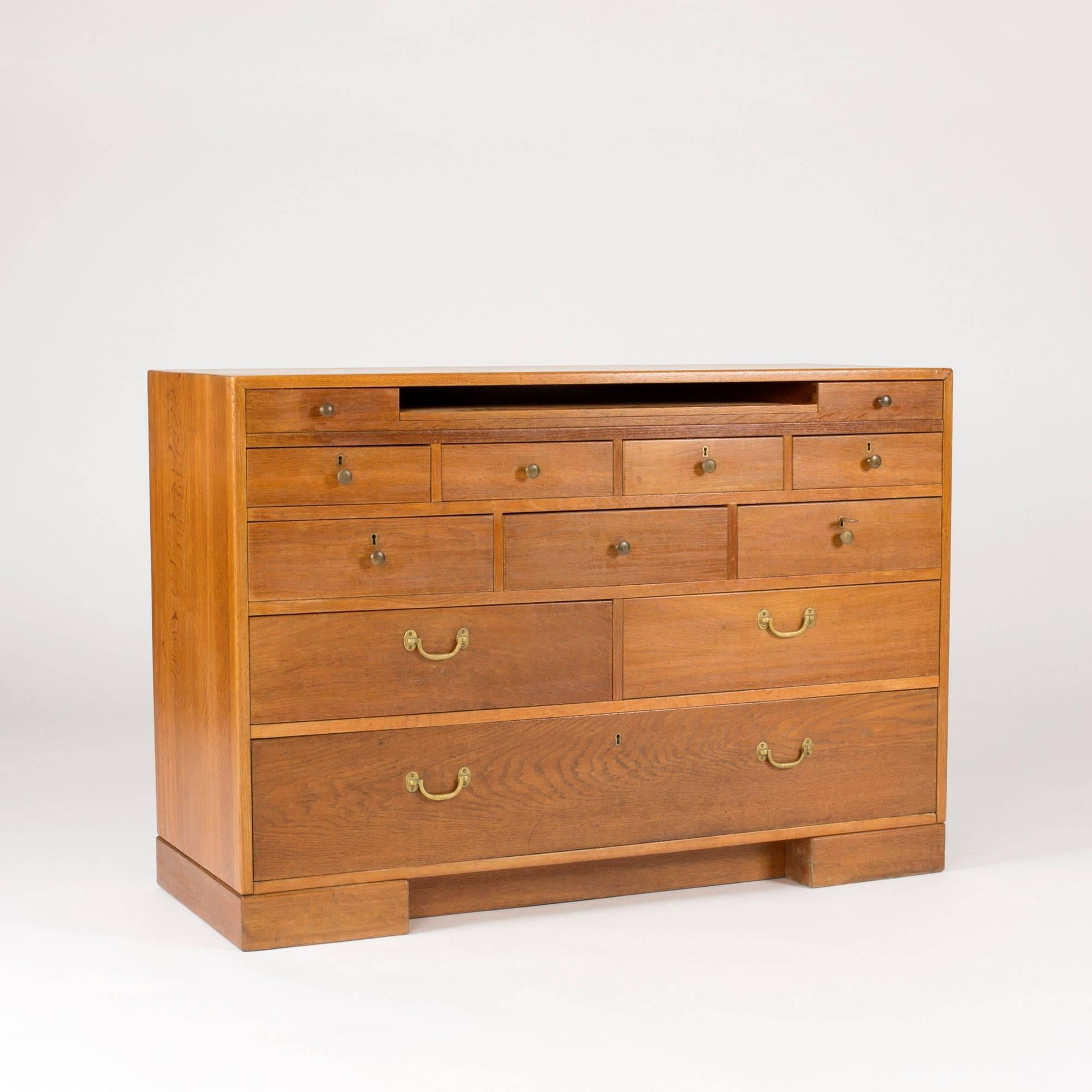 Rare secretaire by Mogens Koch, made in 1936 in a very limited edition for the Sønderborg Statshospital in Denmark, which he designed. Solid oak with brass handles and knobs. Extendable writing leaf dressed with leather and drawers covered by lids.