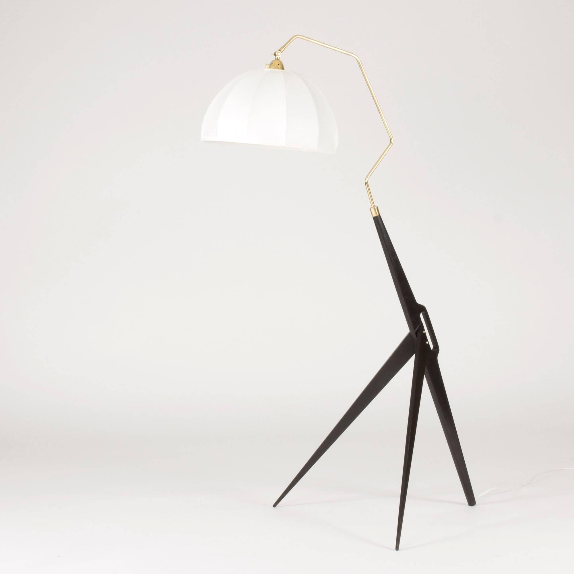 Voluminous prototype floor lamp attributed to Hans Bergström. Wide, wooden, three-legged base with a handle in a style typical of Bergström. A brass pole extends from the base and has been shaped to fit the large shade. Extremely rare and a real