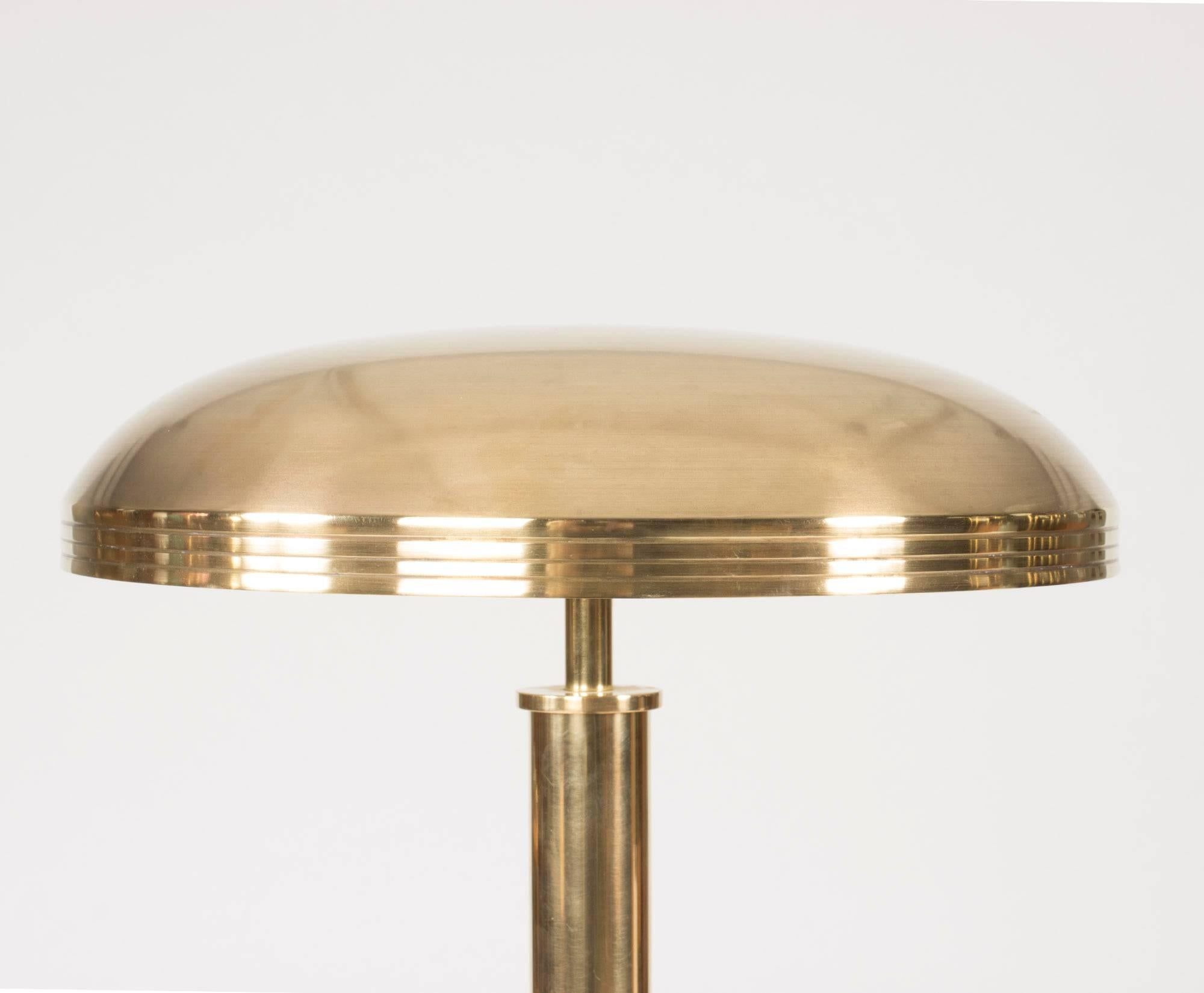 Luxurious brass table lamp from Böhlmarks. Brass shade and handle with a engraved lines, mahogany base.